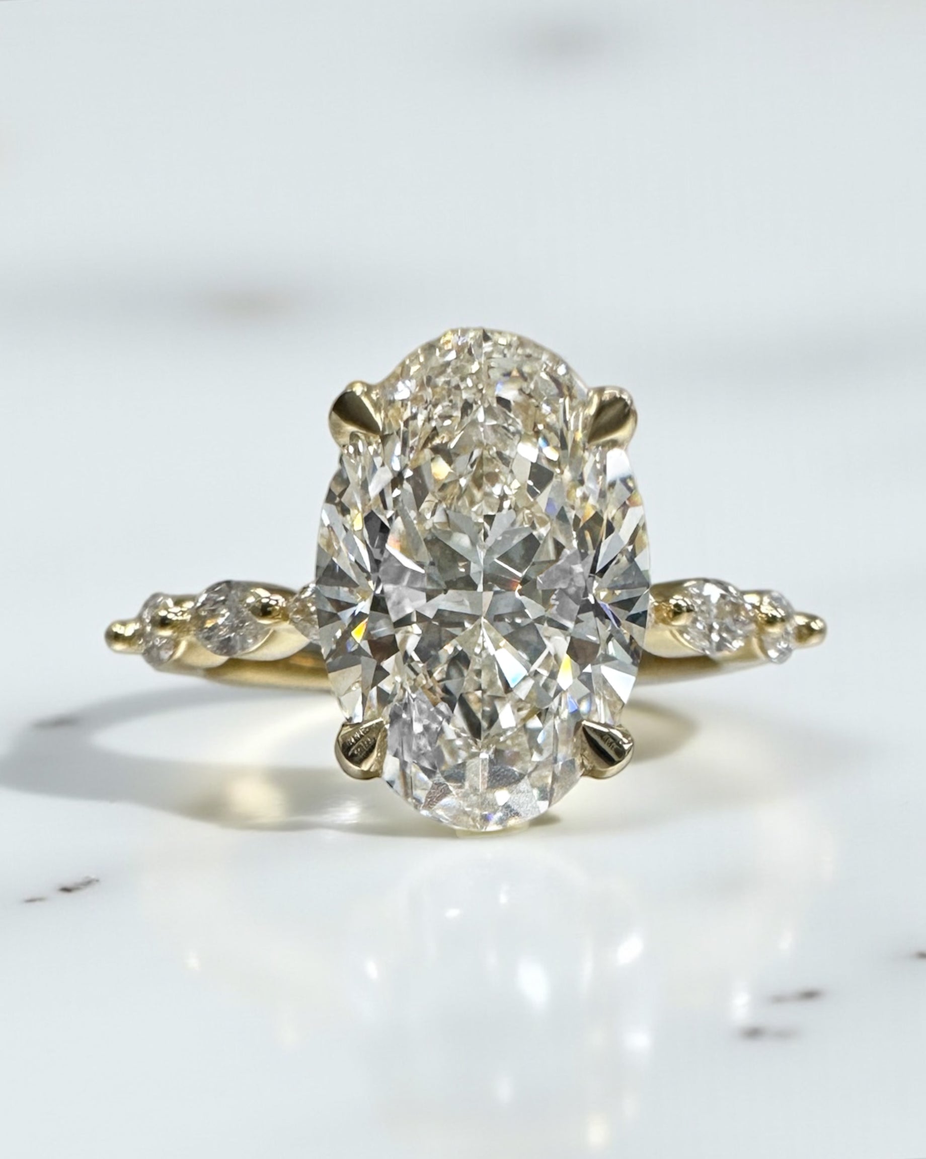 3ct Oval cut lab grown diamond engagement ring with marquise diamond band, crafted in 18kt yellow gold by Layla Diamonds London.