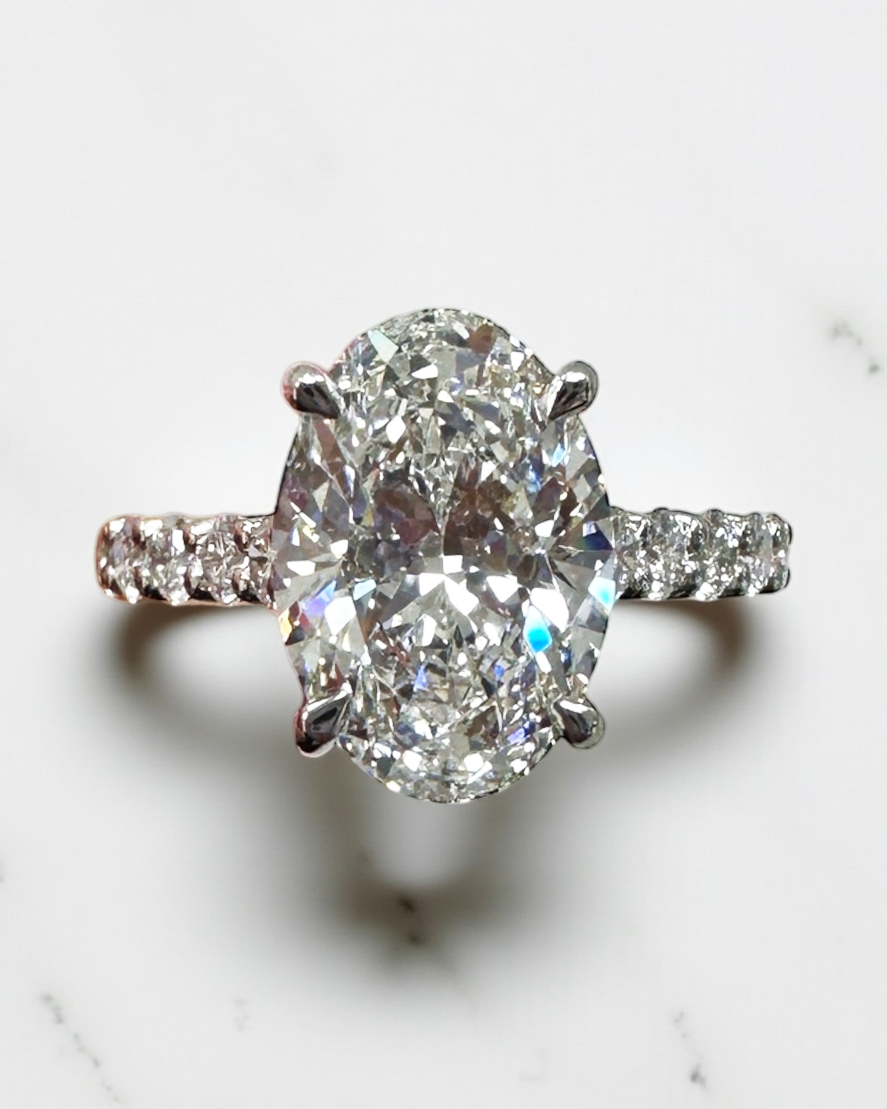 3ct oval cut lab grown diamond u prong setting, cathedral engagement ring in platinum on hand