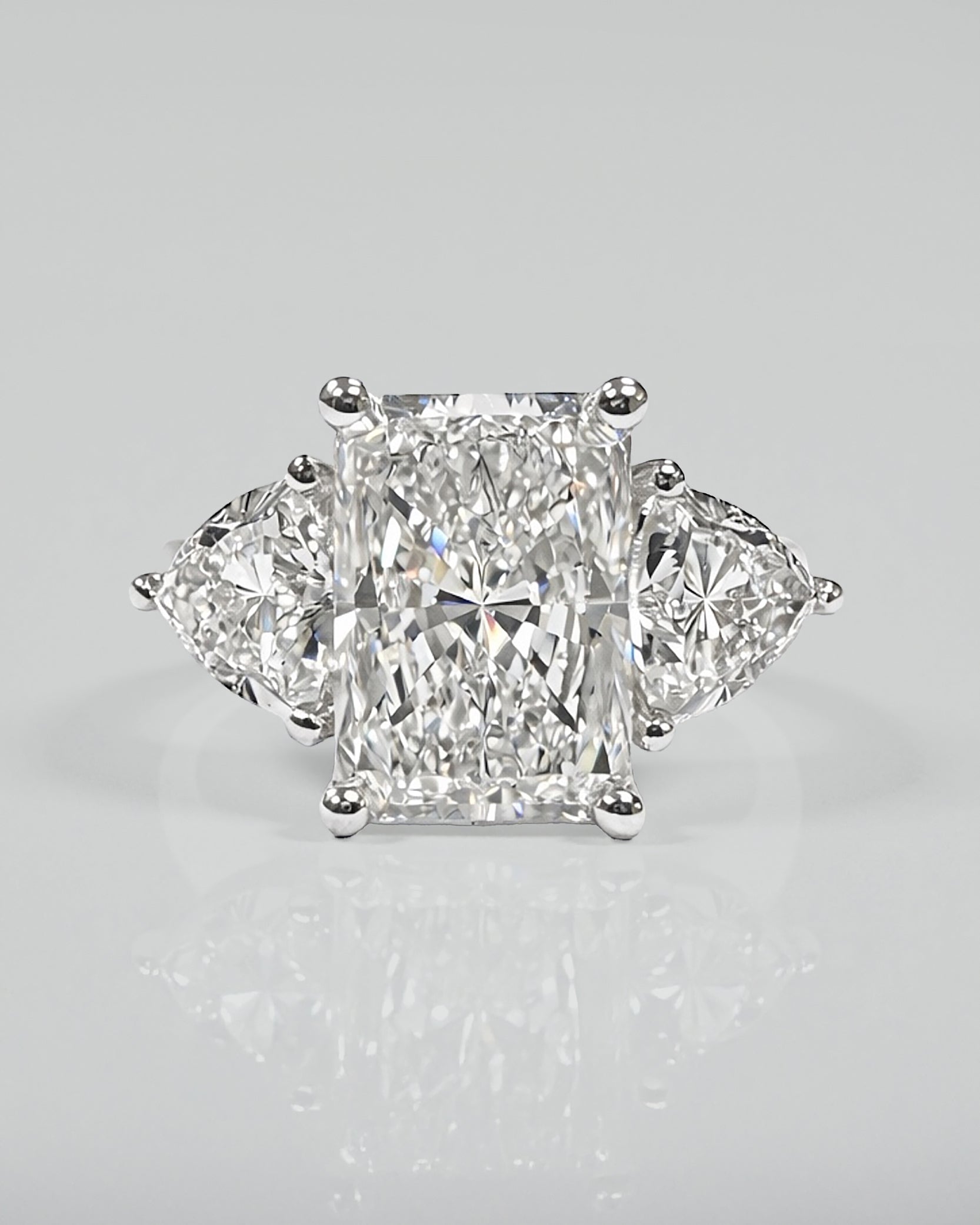 3ct radiant cut lab grown diamond engagement ring UK with trillion side stones, 4.40ct trilogy engagement ring design in polished white gold or platinum handcrafted in London