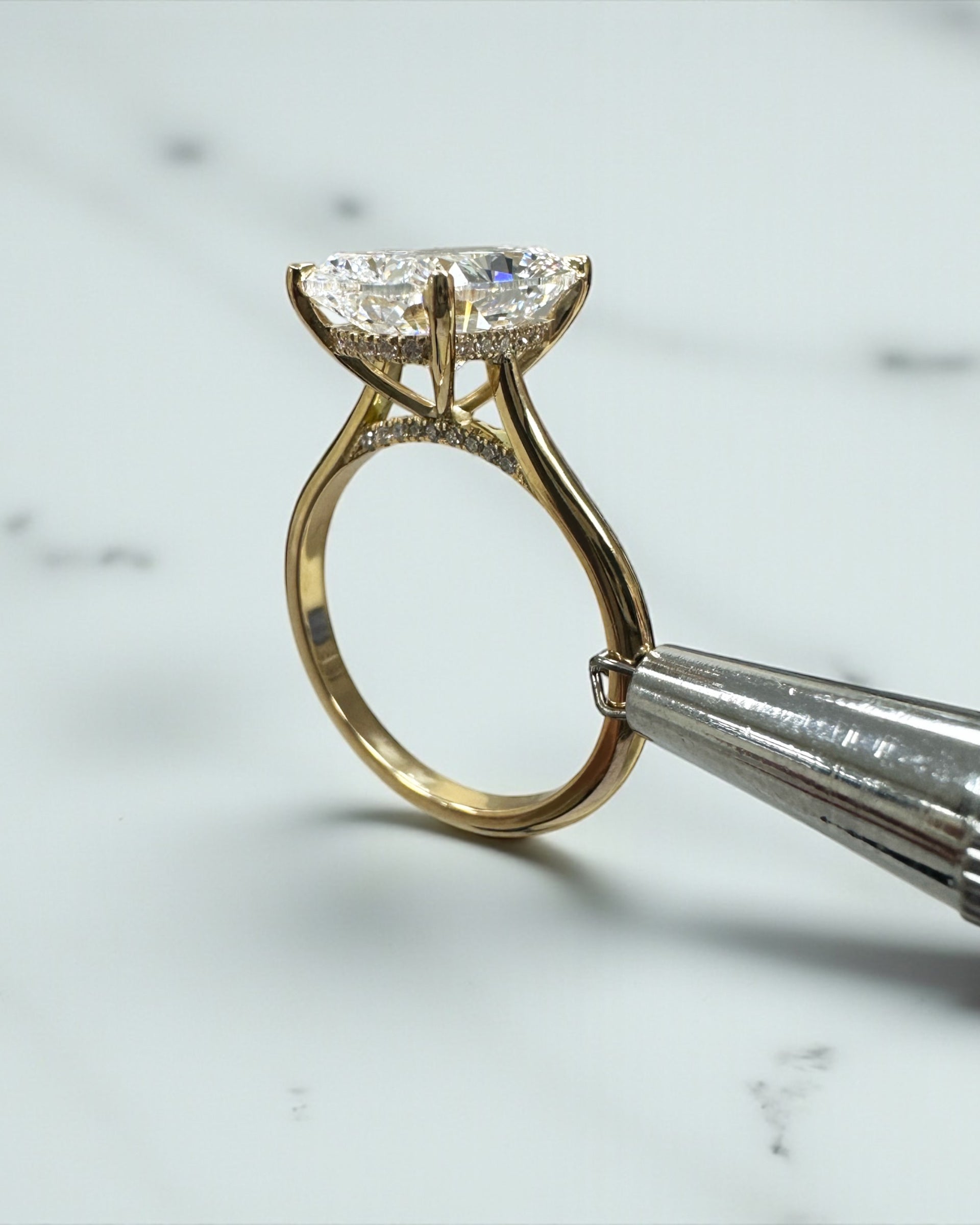 4ct elongated cushion cut lab grown diamond cathedral engagement ring in 18kt yellow gold, diamond bridge and hidden halo