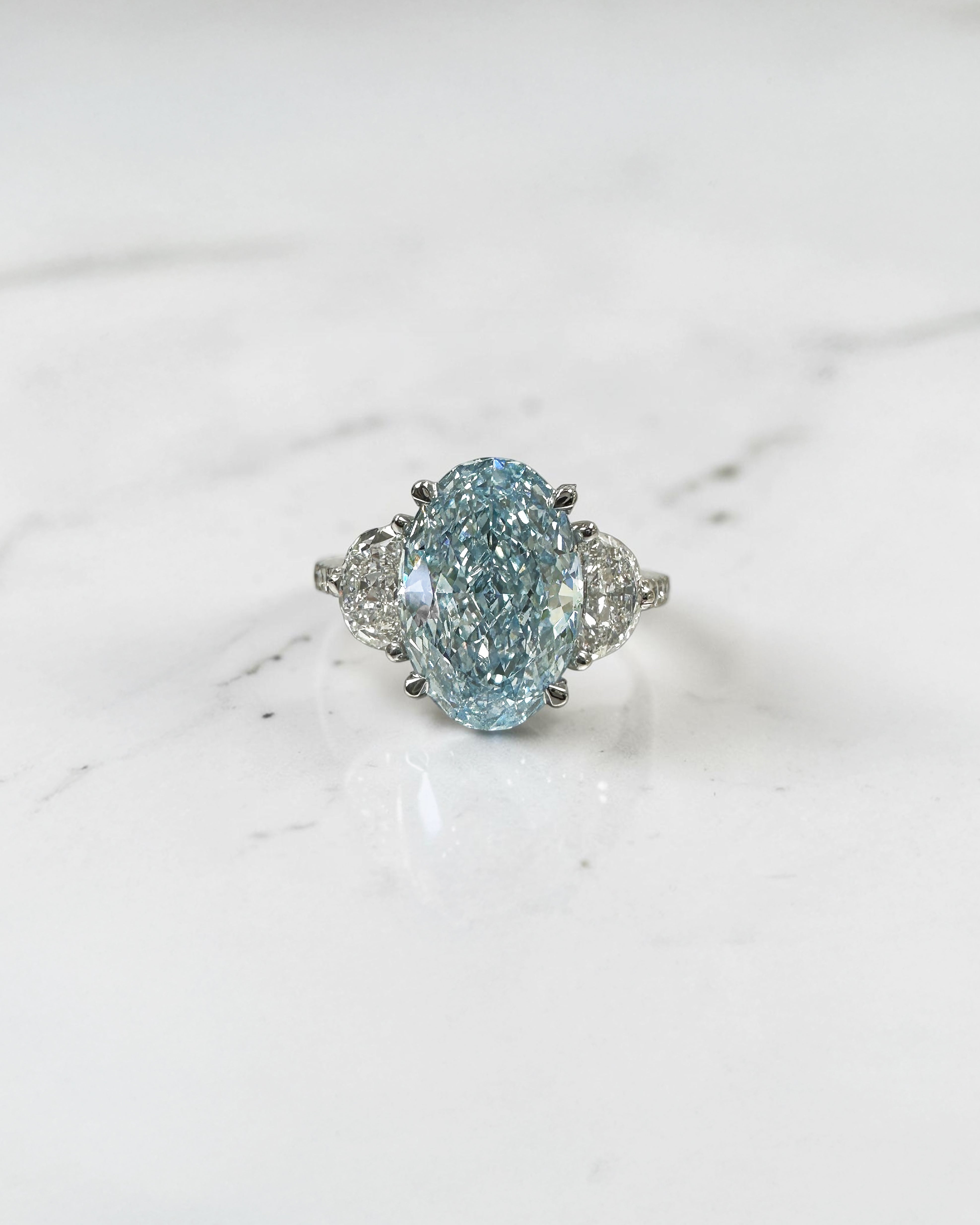 3.70ct baby fancy blue oval cut lab grown diamond trilogy engagement ring with half moon side stones and diamond set tapered shoulders in platinum setting