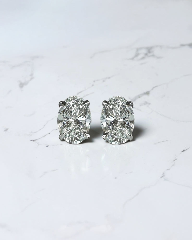 0.70ct oval diamond stud earrings featuring two 0.35ct oval brilliant cut diamonds in a classic four prong setting with secure butterfly backs.
