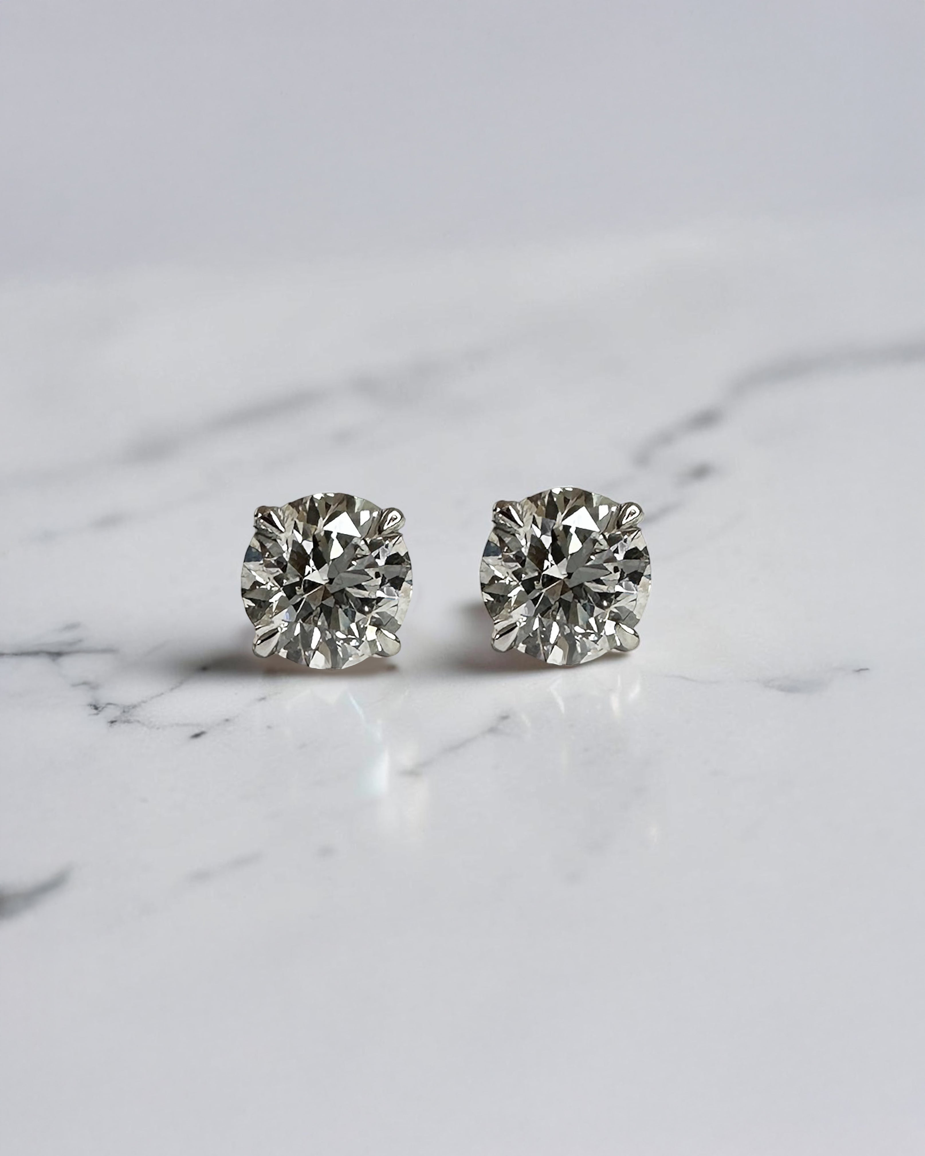 1.20ct round brilliant lab grown diamond stud earrings in a four prong martini setting with E/F colour, VS1+ clarity, available in white gold, yellow gold or platinum.