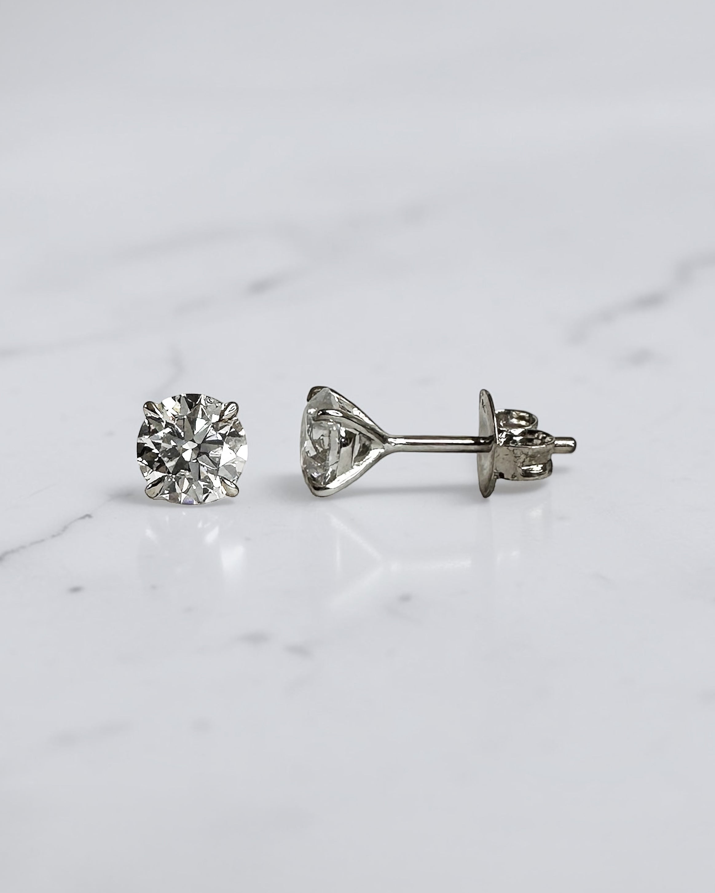 1.20ct round brilliant lab grown diamond stud earrings in a four prong martini setting with E/F colour, VS1+ clarity, available in white gold, yellow gold or platinum.