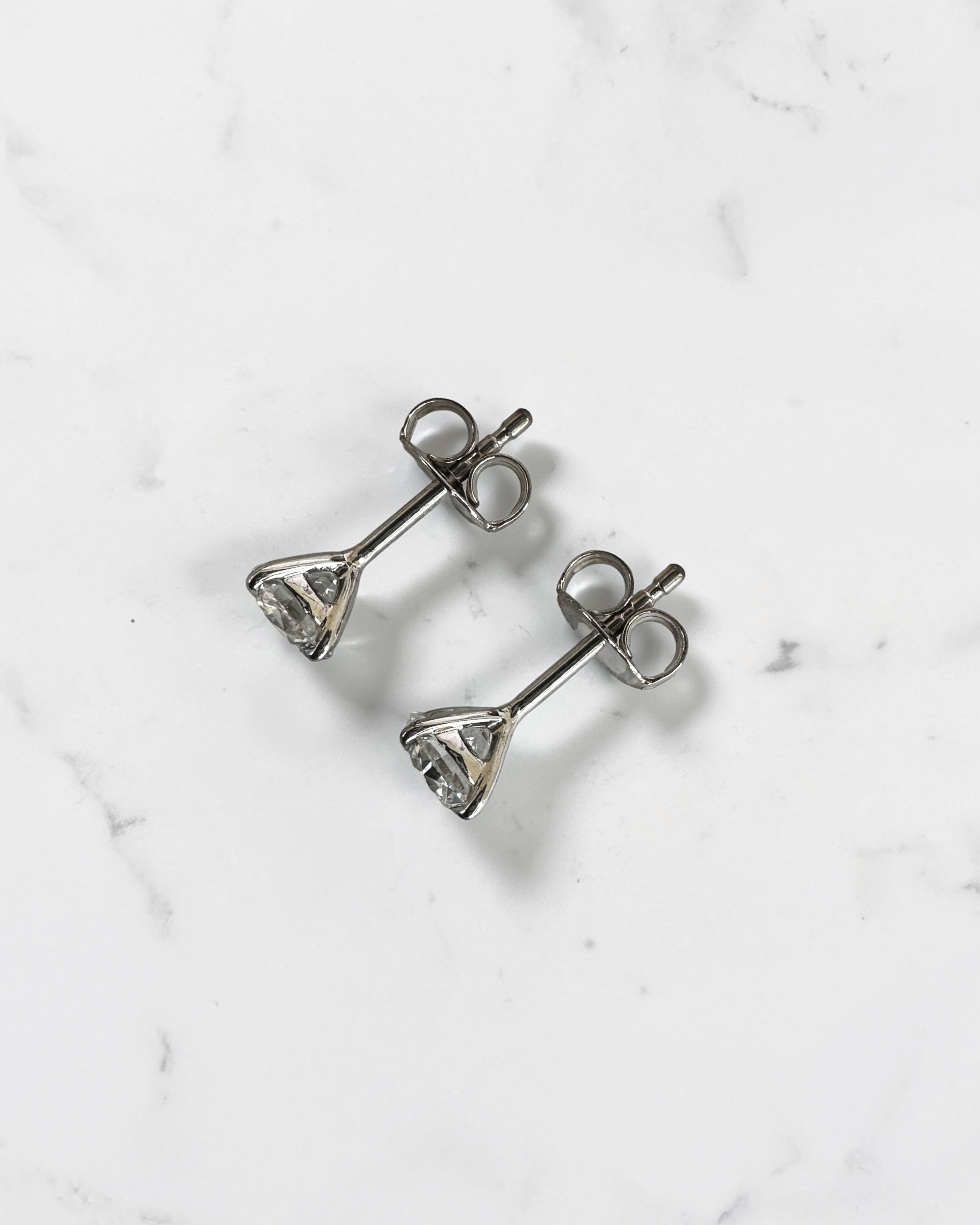 1.20ct round brilliant lab grown diamond stud earrings in a four prong martini setting with E/F colour, VS1+ clarity, available in white gold, yellow gold or platinum.