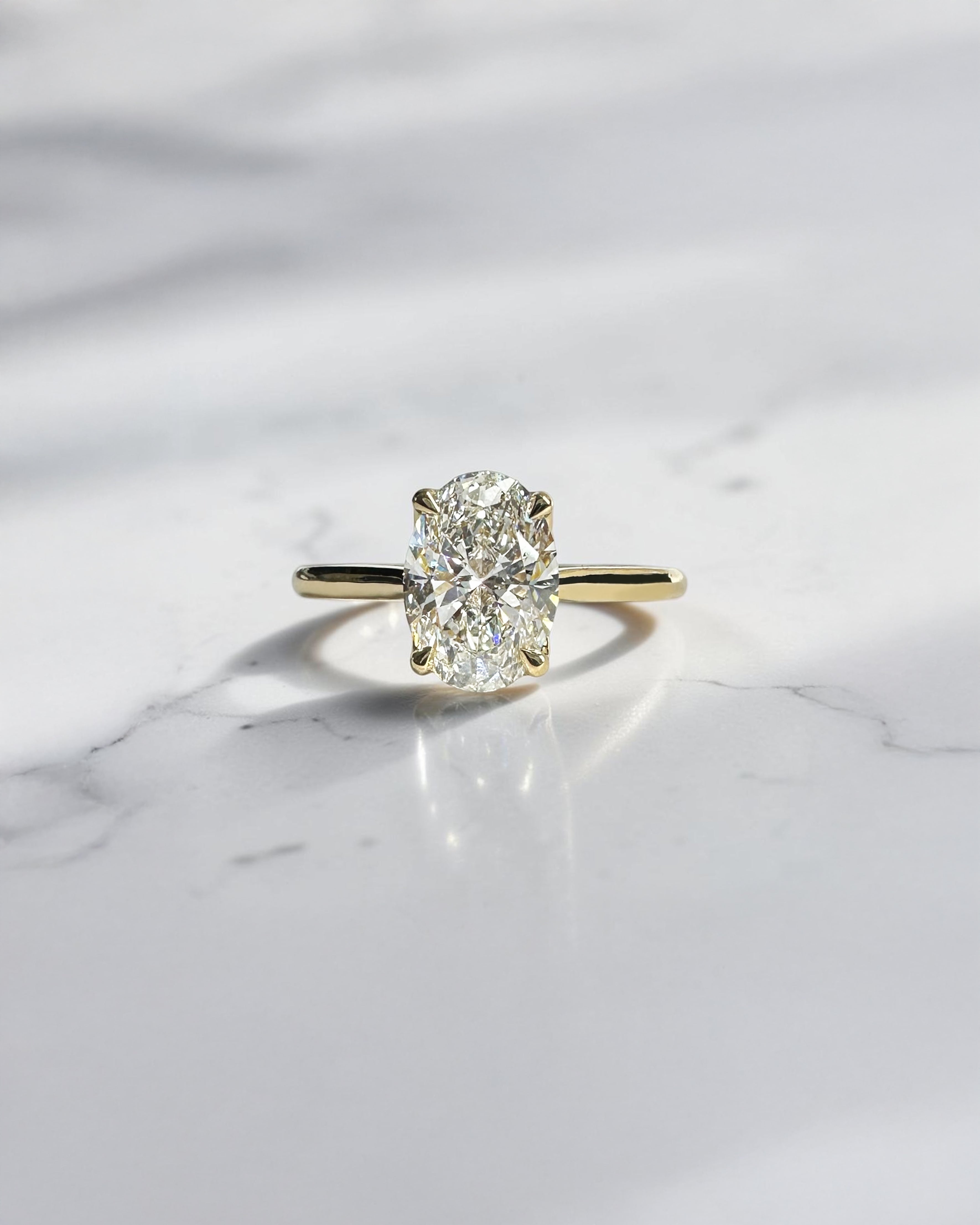 Oval cut diamond cathedral engagement ring with hidden diamond bridge in 18kt yellow gold, approx 1.60ct total