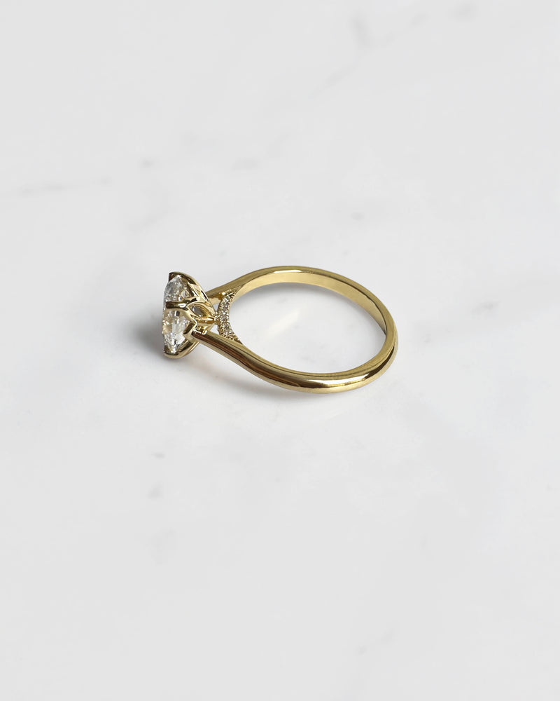 Close up of oval diamond engagement ring with hidden pavé bridge and cathedral setting