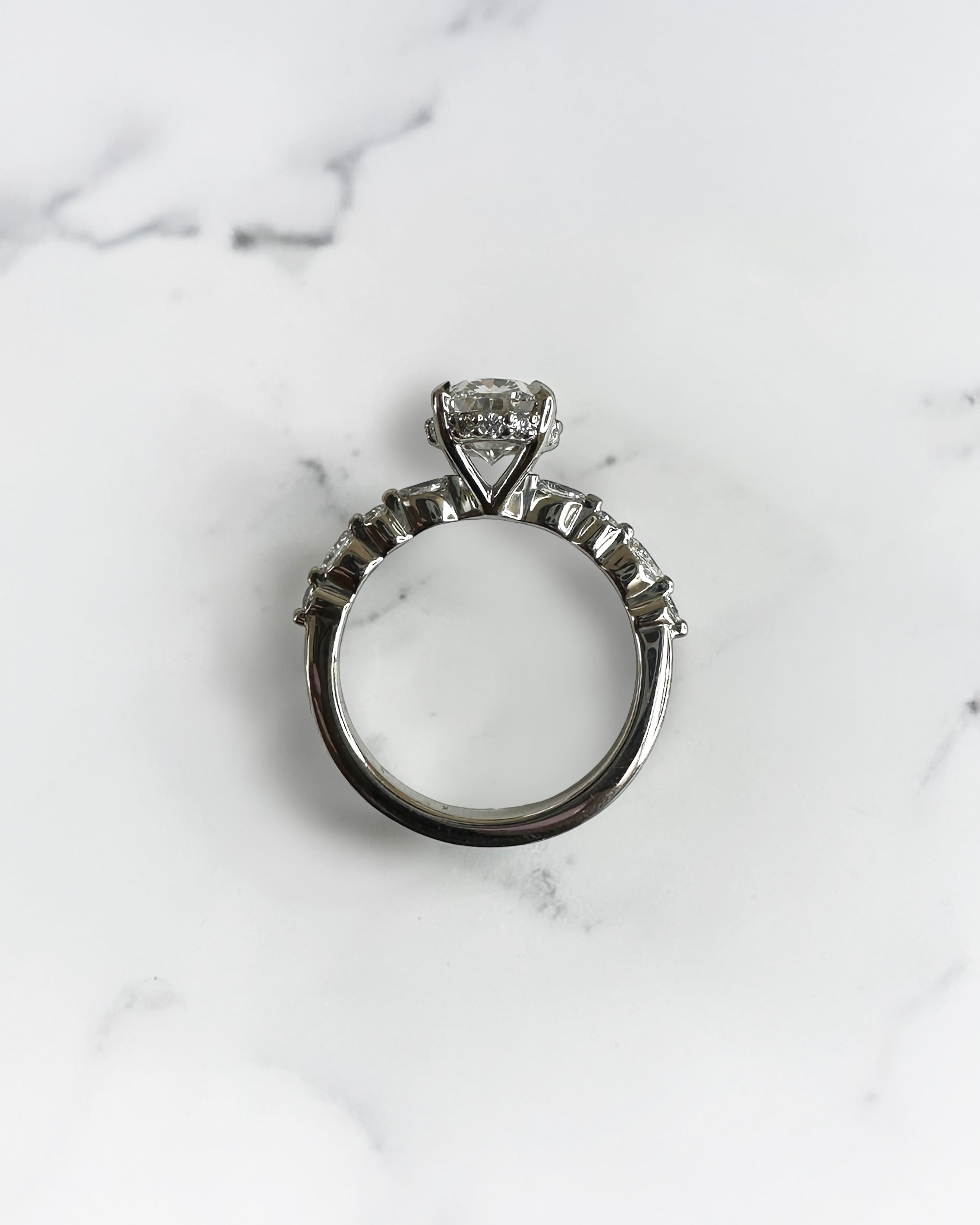 1.50ct oval cut lab grown diamond engagement ring with marquise and round diamond shoulders and hidden halo
