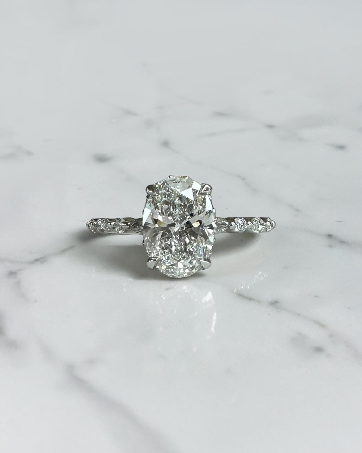 1.50ct oval cut lab grown diamond engagement ring with marquise and round diamond shoulders and hidden halo