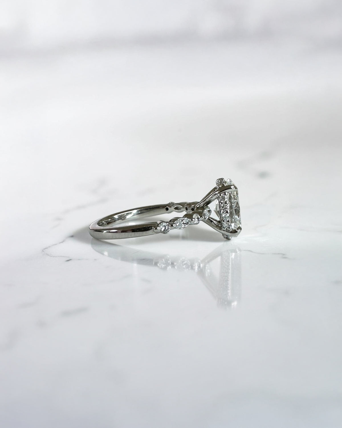 1.50ct oval cut lab grown diamond engagement ring with marquise and round diamond shoulders and hidden halo