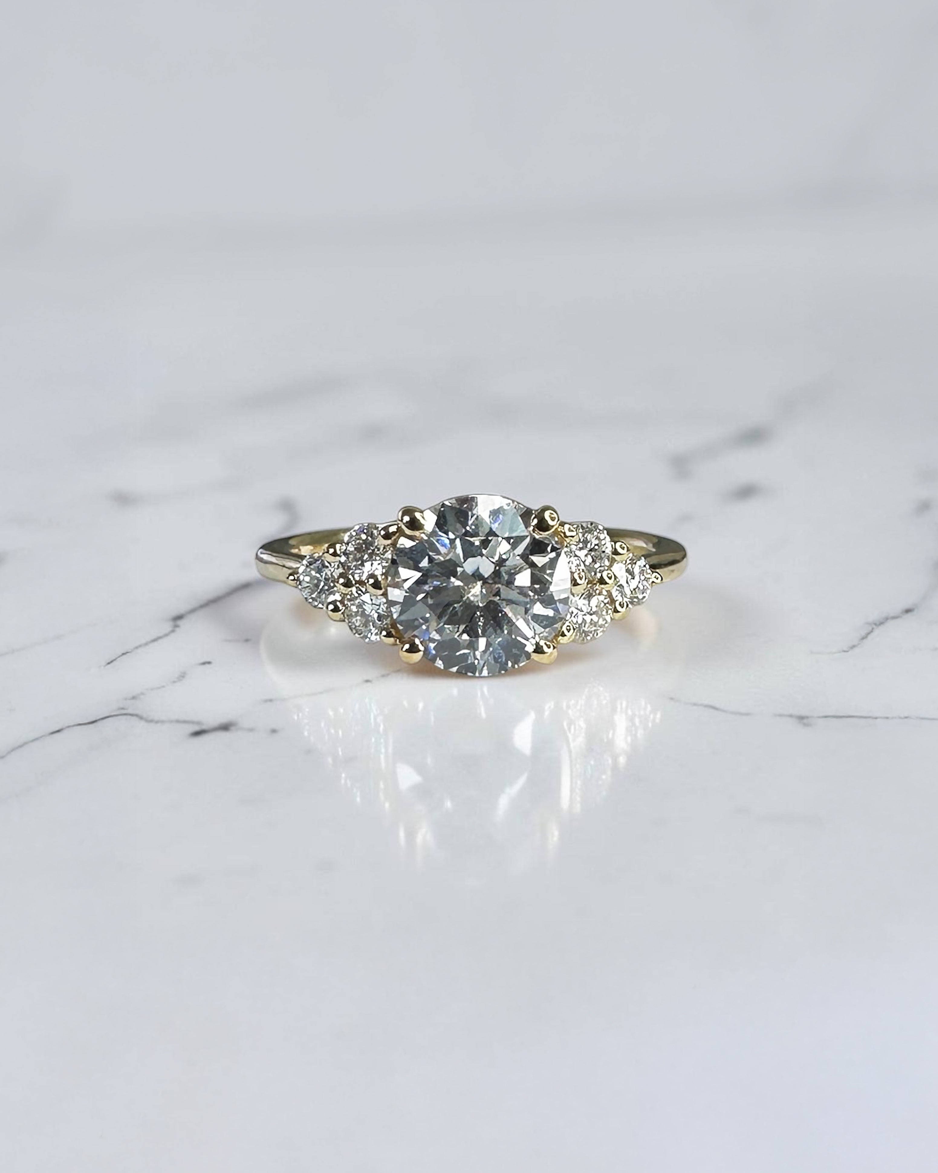1.50ct round brilliant lab grown diamond trefoil engagement ring with diamond cluster shoulders in yellow gold.