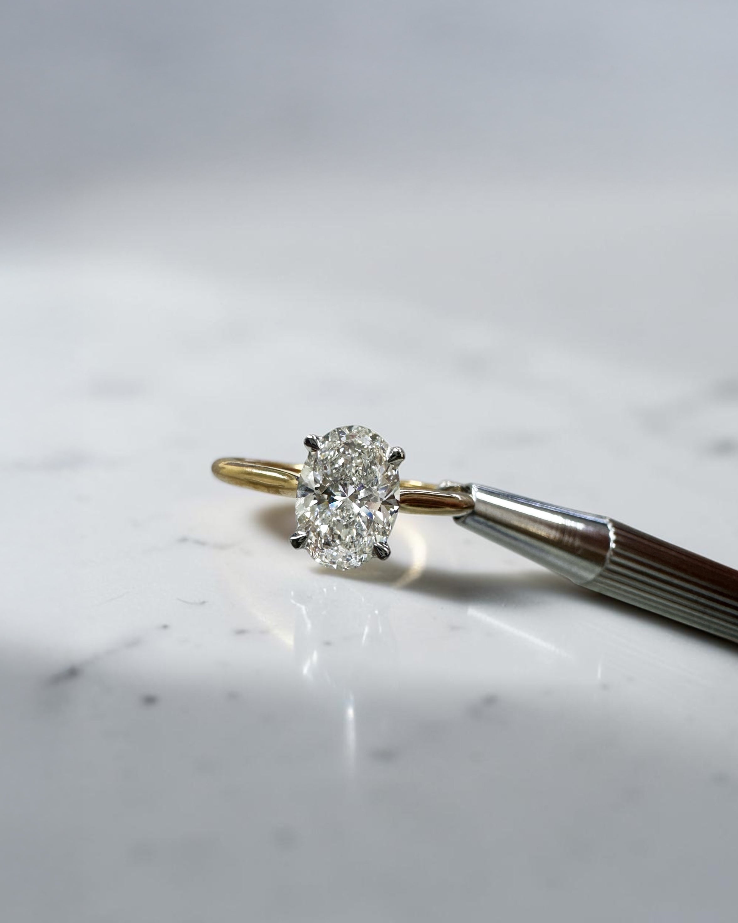 Oval cut diamond solitaire engagement ring 1.50ct, cathedral setting, two tone yellow gold band and platinum head