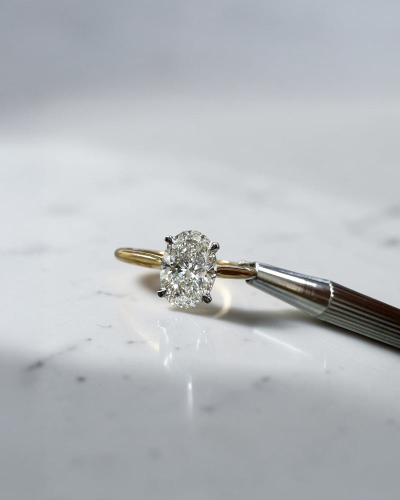 Oval cut diamond solitaire engagement ring 1.50ct, cathedral setting, two tone yellow gold band and platinum head