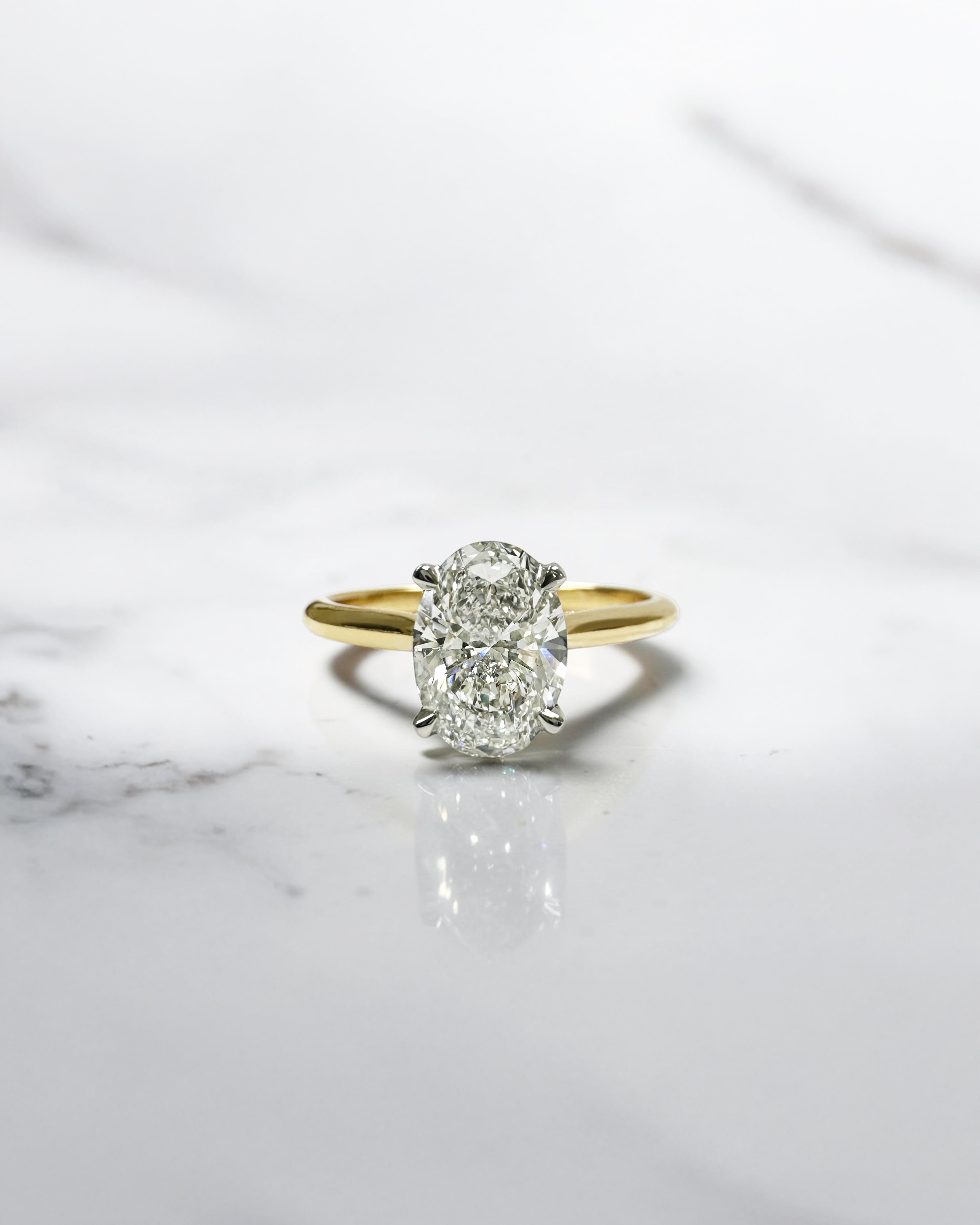 Oval cut diamond cathedral engagement ring 1.50ct, two tone yellow gold band with platinum head, hidden diamond bridge detail