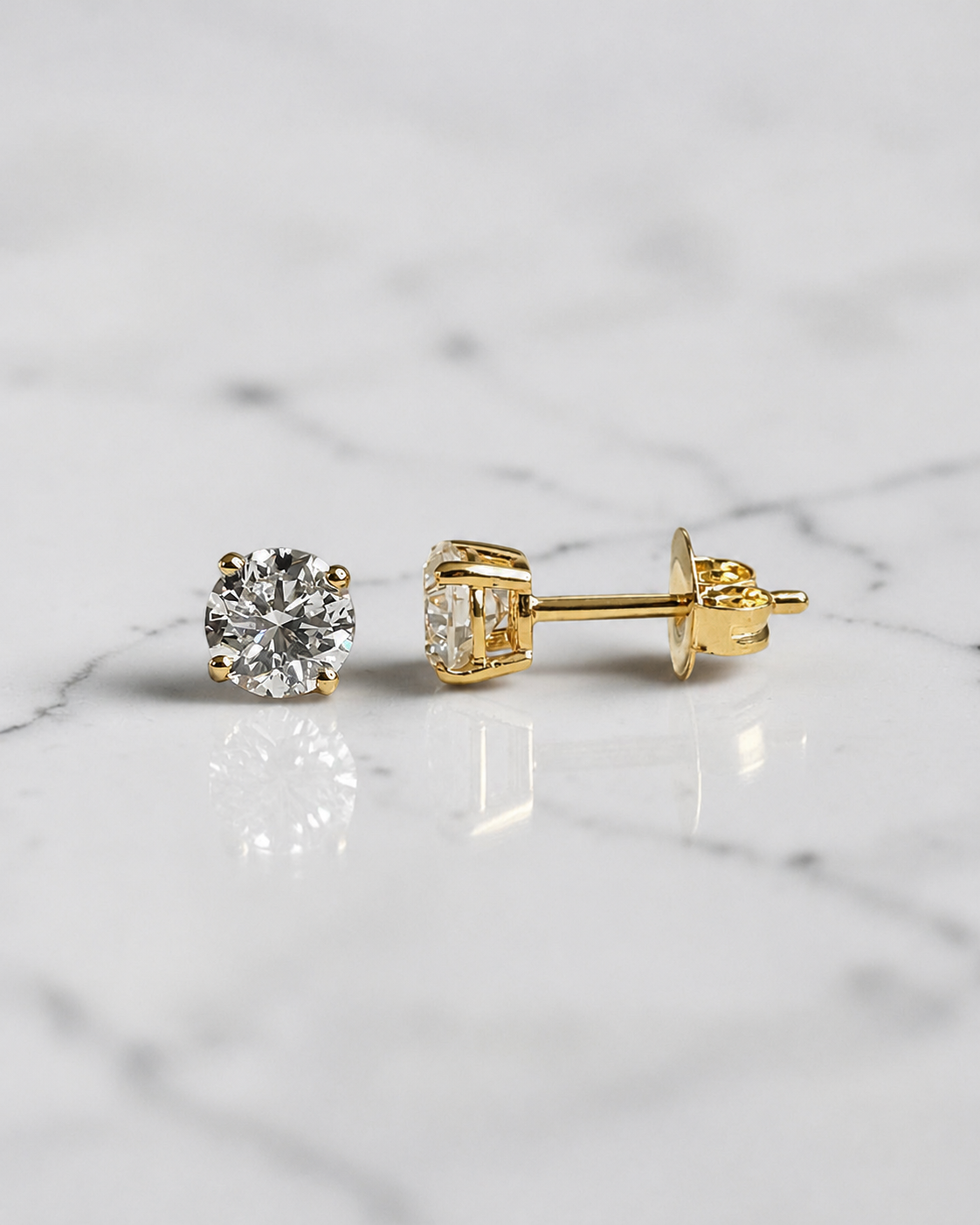 1ct round brilliant lab grown diamond stud earrings with 0.50ct diamonds in a classic four claw basket setting, available in white gold, yellow gold or platinum.