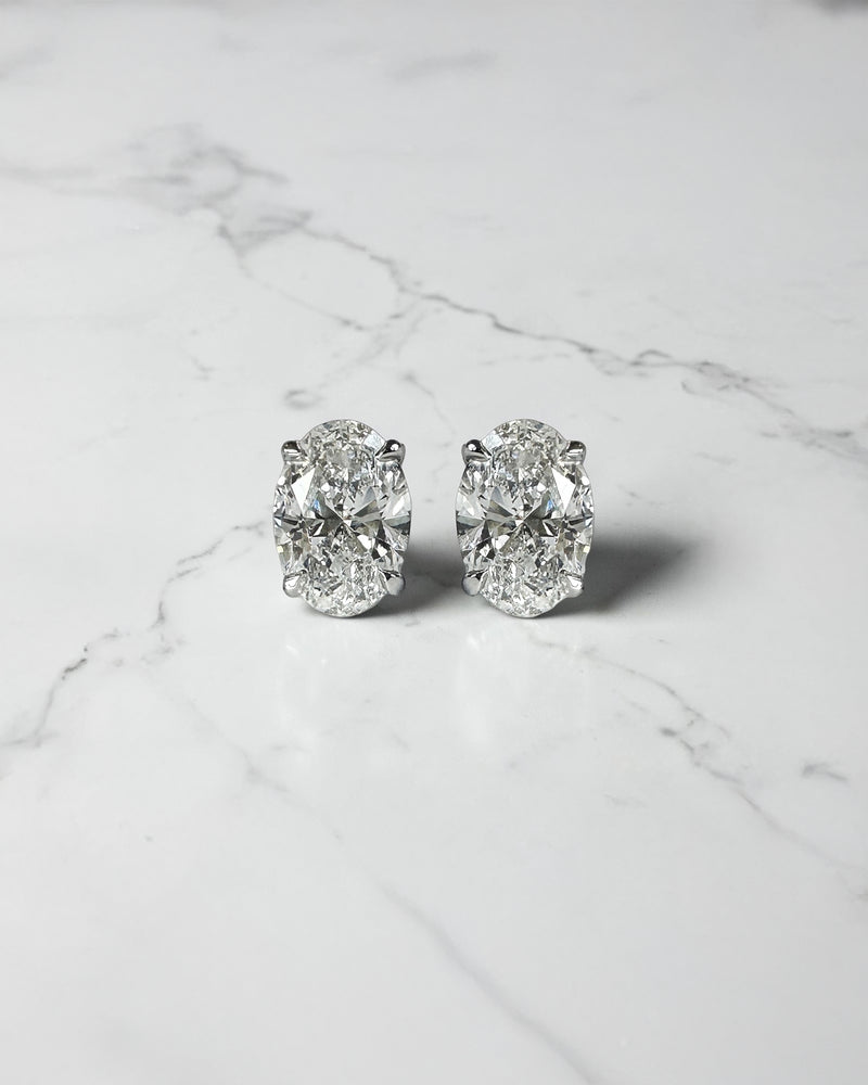 1ct oval diamond stud earrings featuring two 0.50ct oval brilliant cut diamonds in a classic four prong setting, available in platinum or gold.