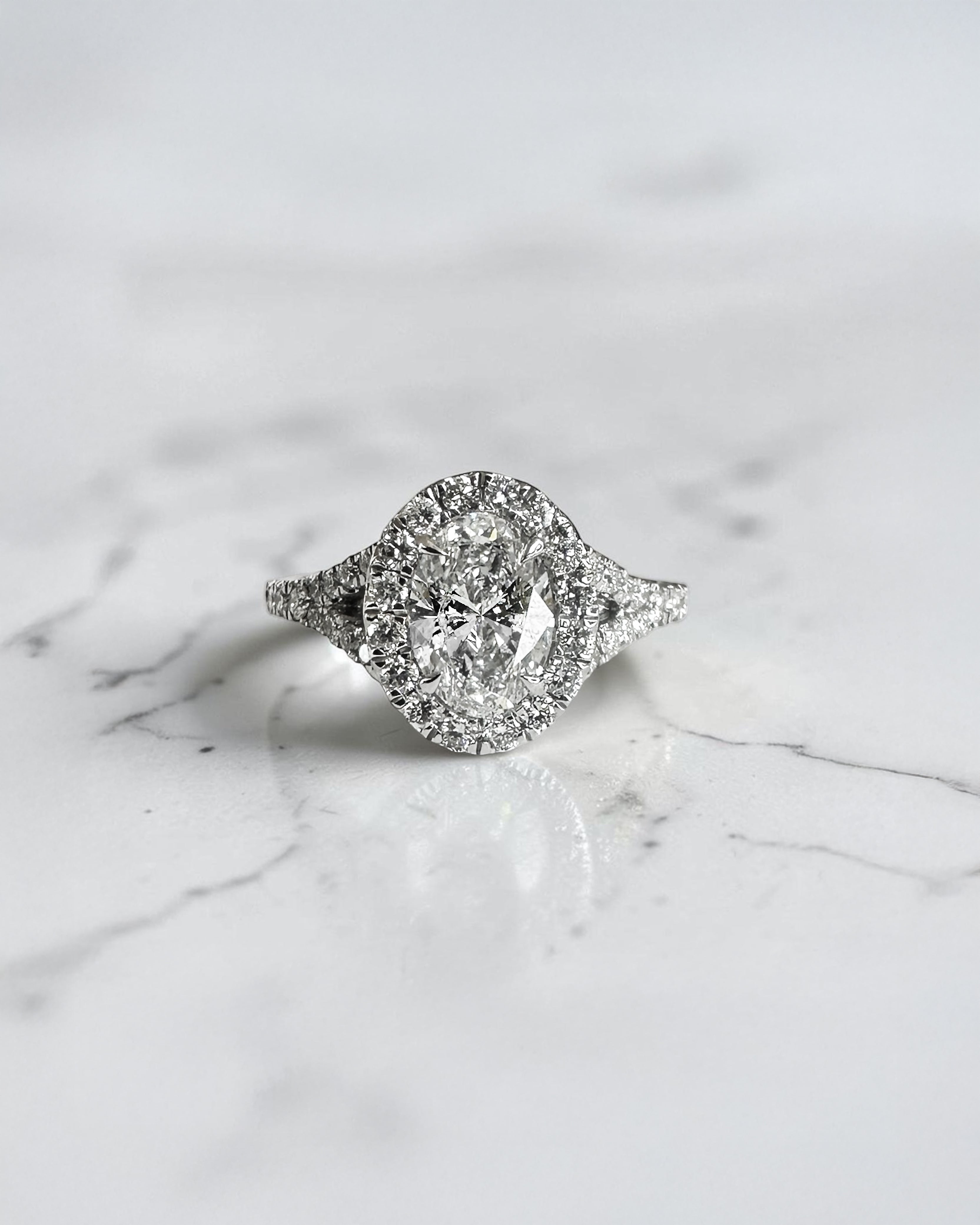 1ct oval cut lab grown diamond halo engagement ring with diamond set split shoulders in white gold
