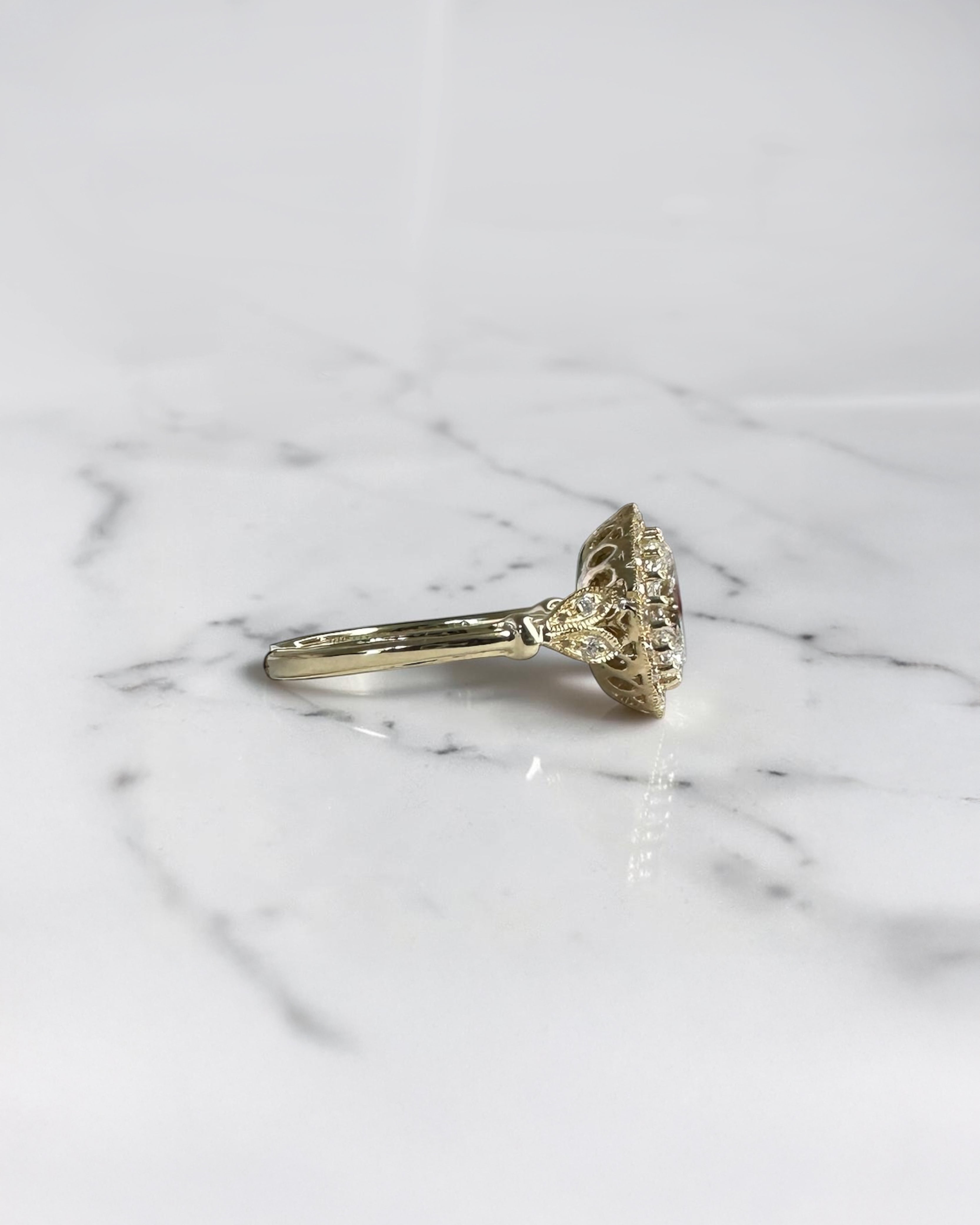 1ct oval vintage style halo diamond engagement ring in yellow gold with diamond halo, vintage shoulders and intricate gallery detail.