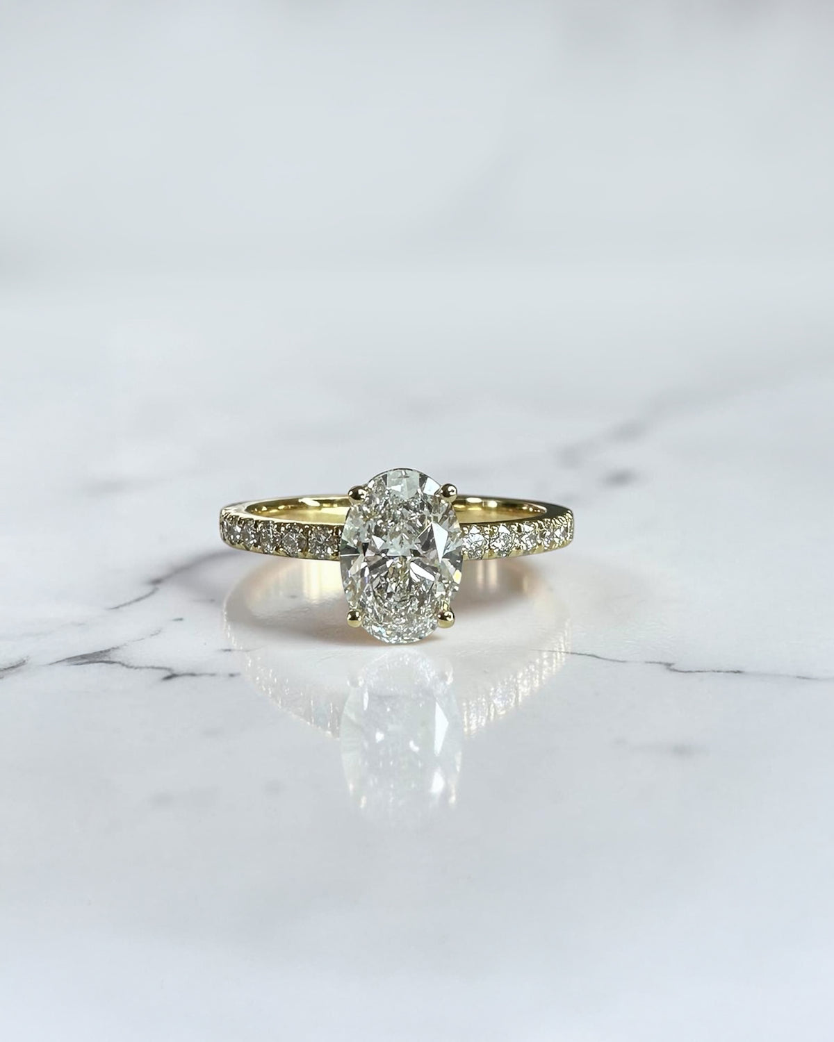 1ct oval cut lab grown diamond engagement ring with wrap around hidden halo and diamond shoulder band