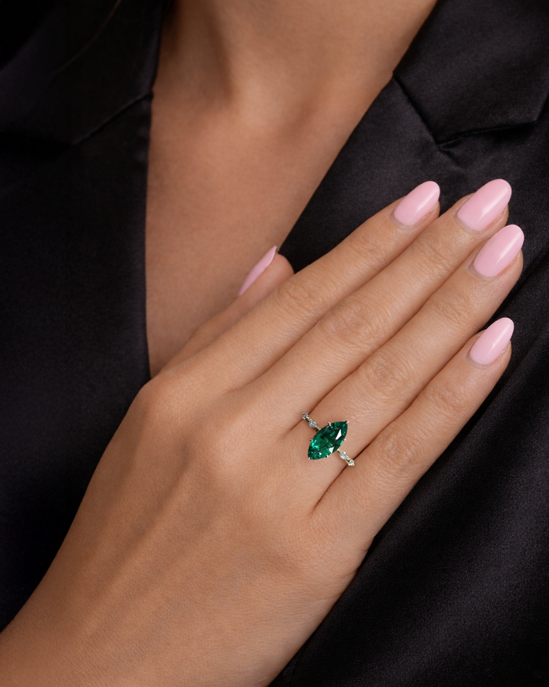 Close-up of a 2.40 carat green emerald marquise engagement ring.