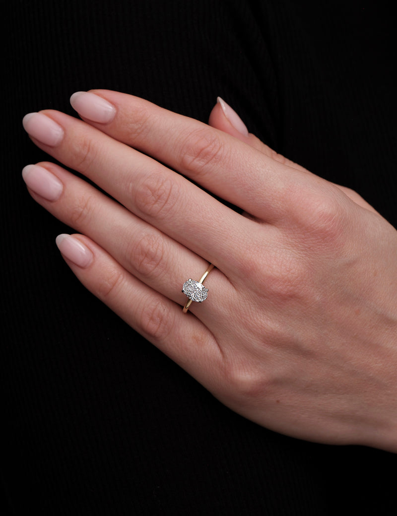 1.25ct oval cut lab grown diamond hidden halo solitaire engagement ring on hand with platinum head by Layla Diamonds.