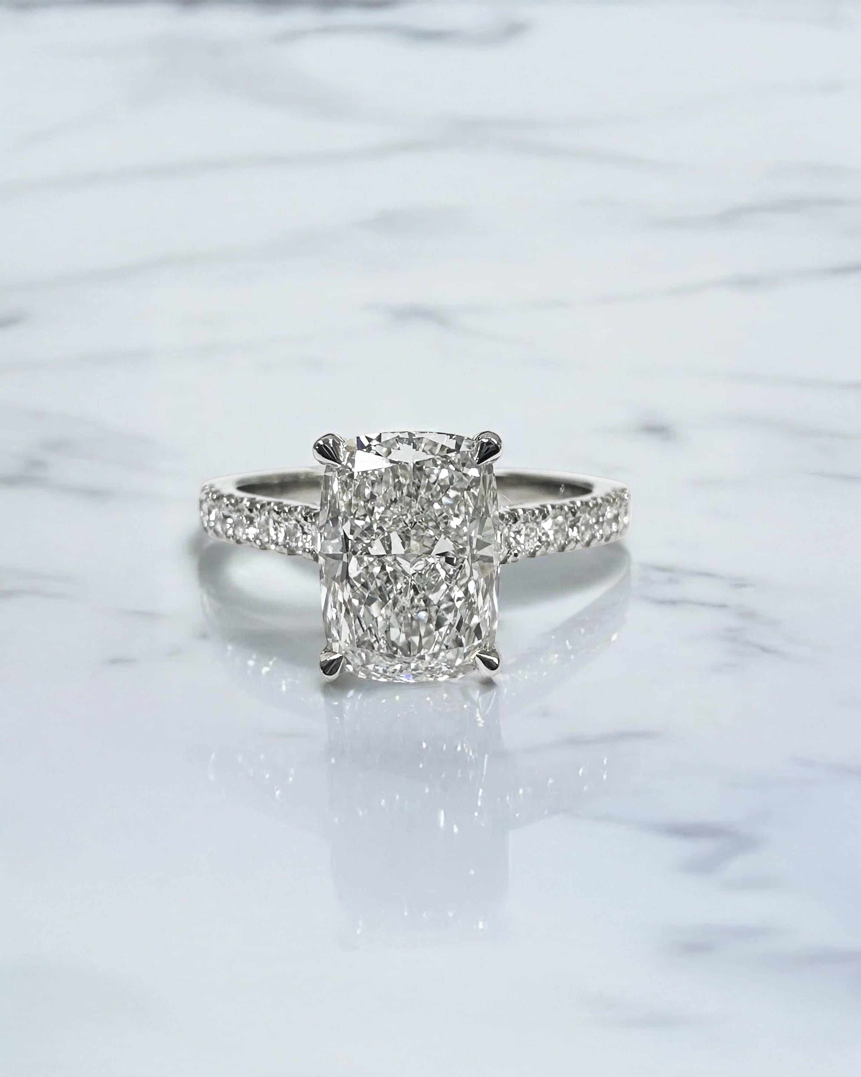 2ct elongated cushion cut lab grown diamond engagement ring with cathedral setting, hidden halo, diamond bridge and diamond shoulder band.