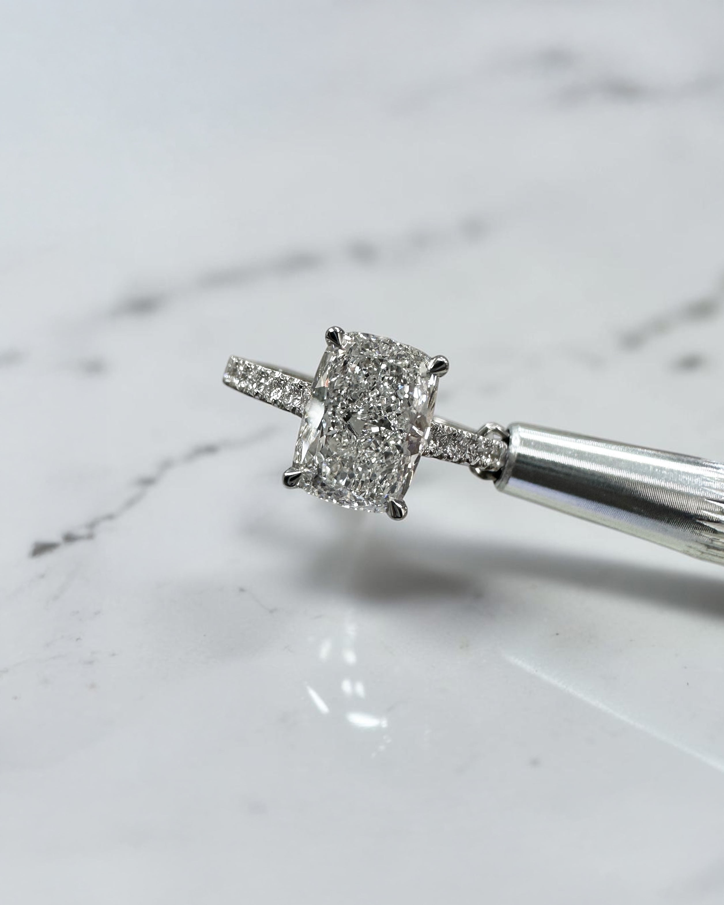 2ct elongated cushion cut lab grown diamond engagement ring with cathedral setting, hidden halo, diamond bridge and diamond shoulder band.