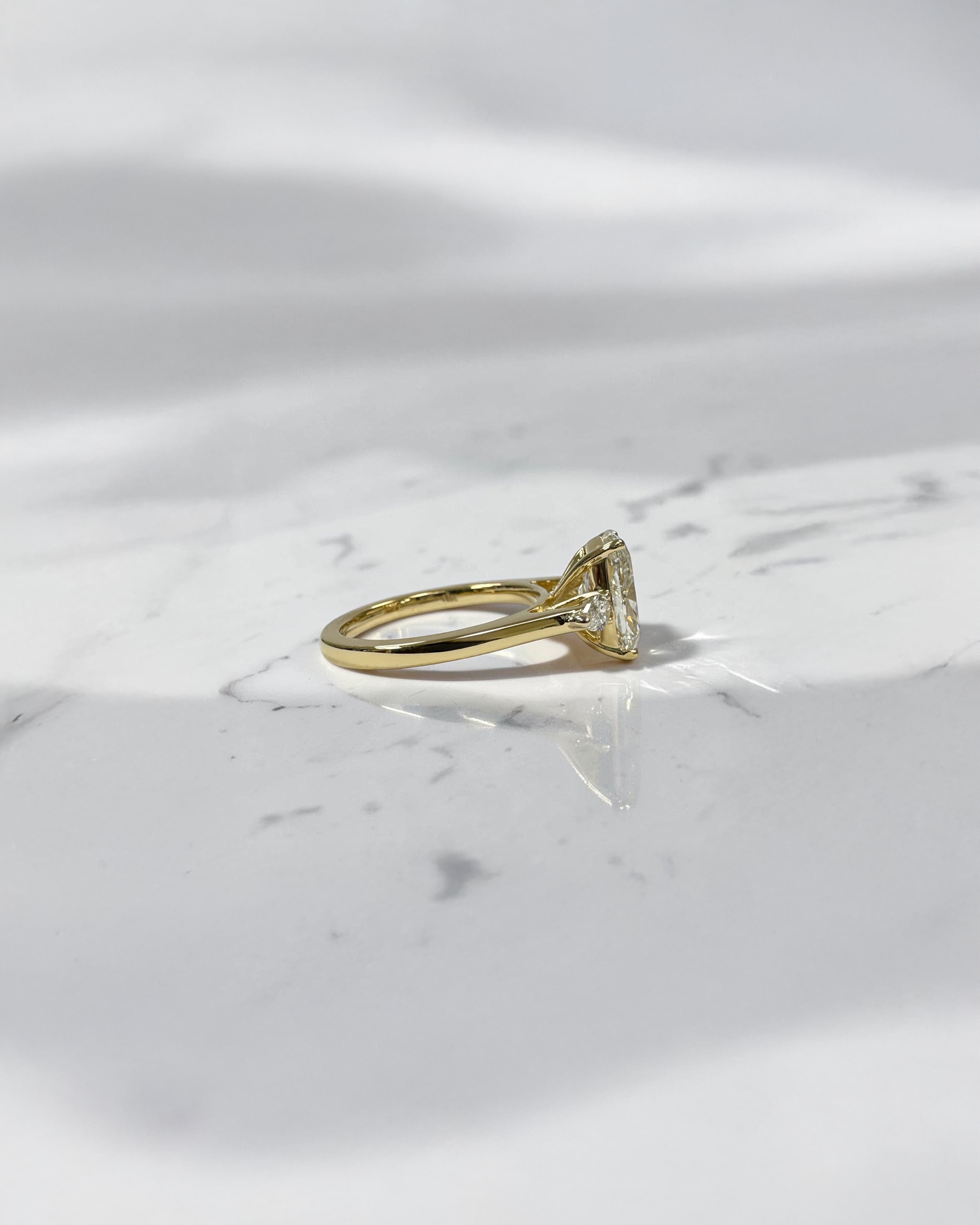 elongated cushion cut diamond trilogy ring 2ct centre with pear diamond side stones 18kt yellow gold engagement ring