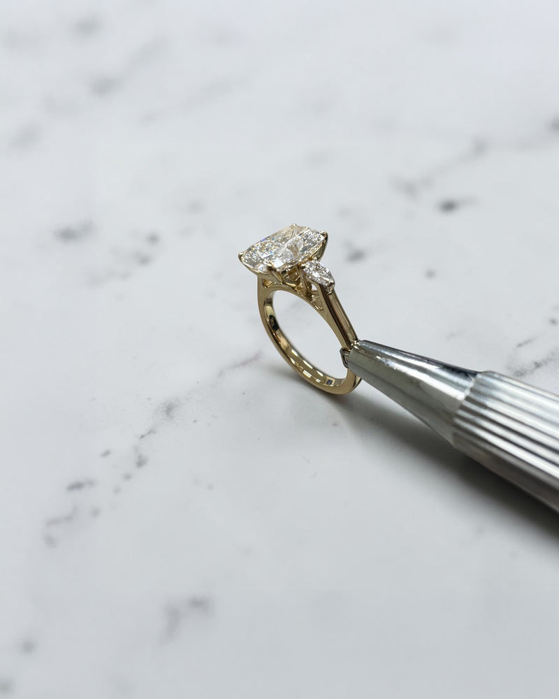 elongated cushion cut diamond trilogy ring 2ct centre with pear diamond side stones 18kt yellow gold engagement ring