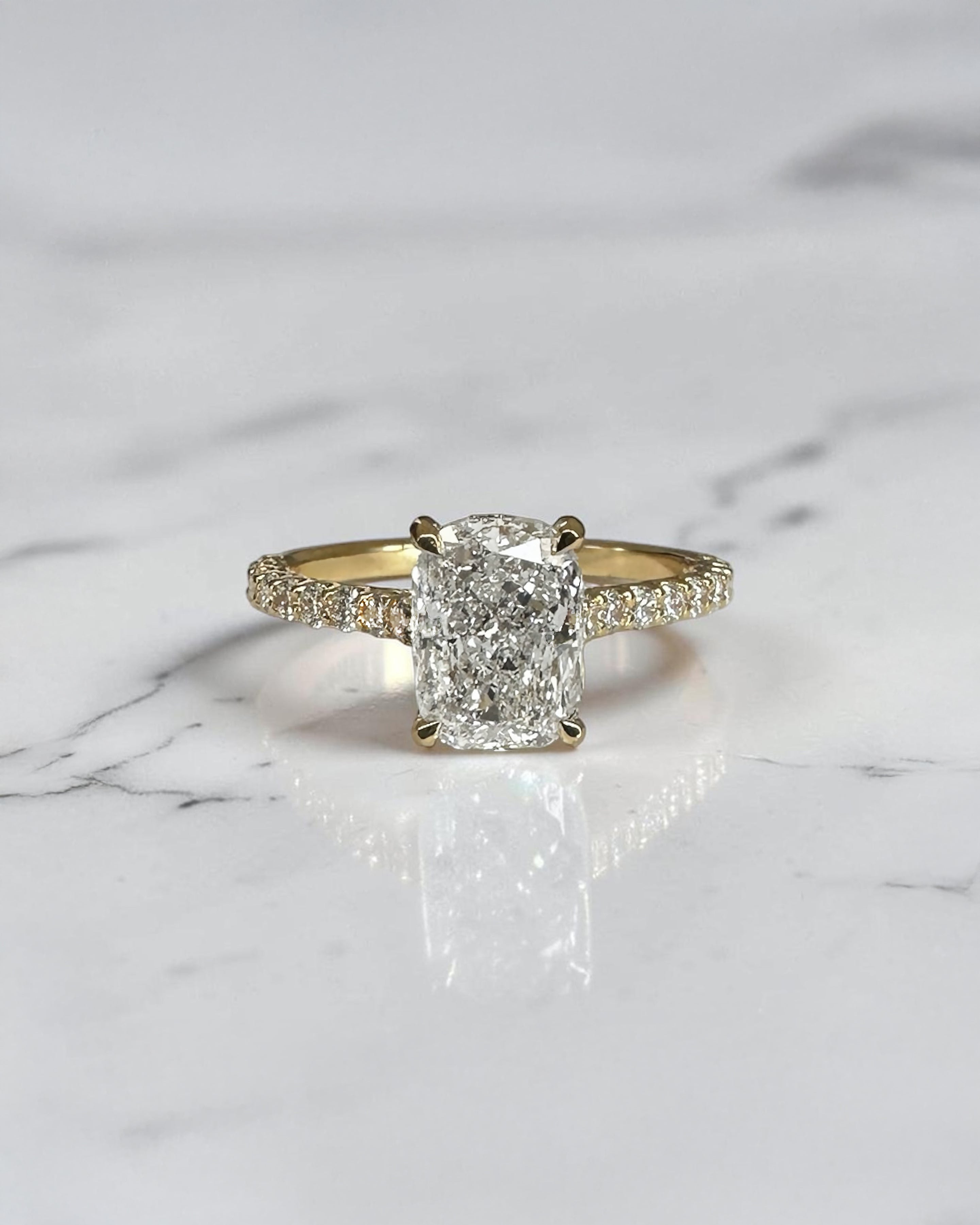 2ct elongated cushion cut lab grown diamond engagement ring with U prong cathedral setting and diamond shoulders in yellow gold