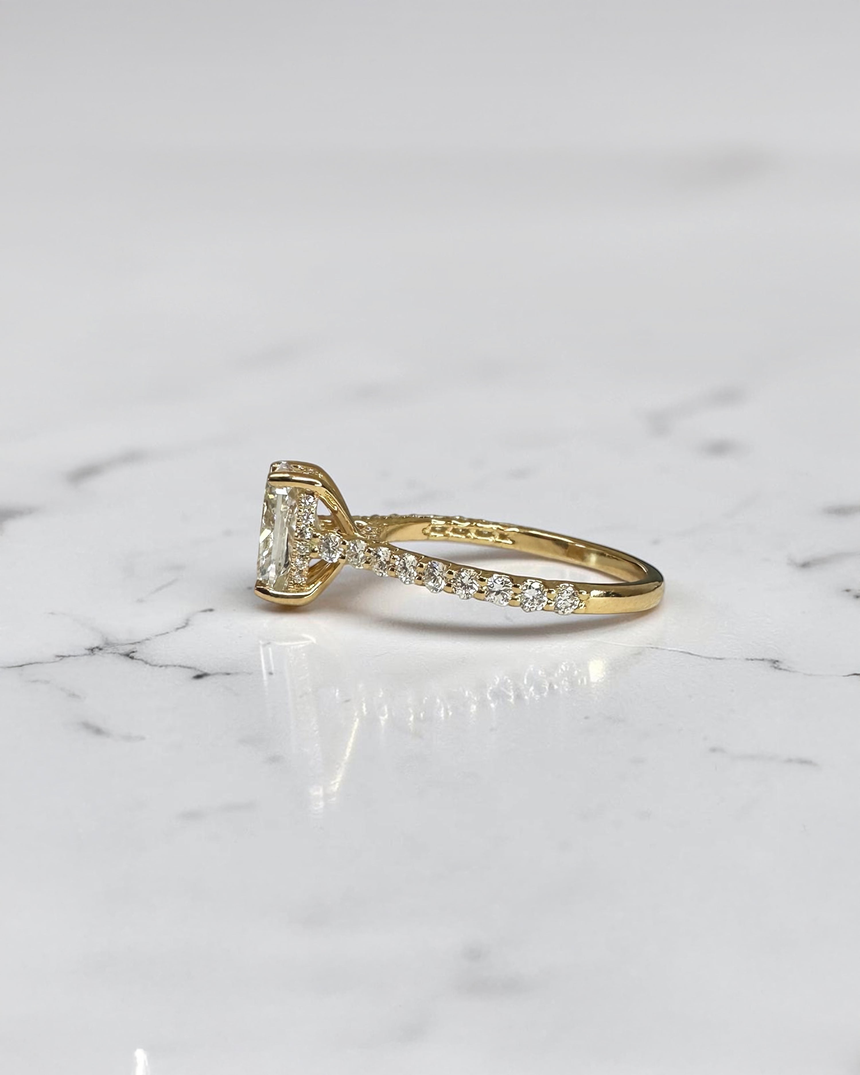 2ct elongated cushion cut lab grown diamond engagement ring with U prong cathedral setting and diamond shoulders in yellow gold