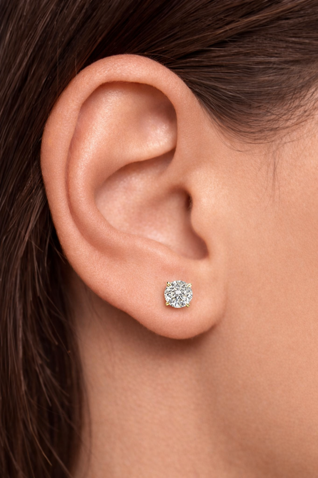 2ct total lab grown diamond stud earrings in martini setting on ear, round brilliant diamonds in yellow gold. Made in London