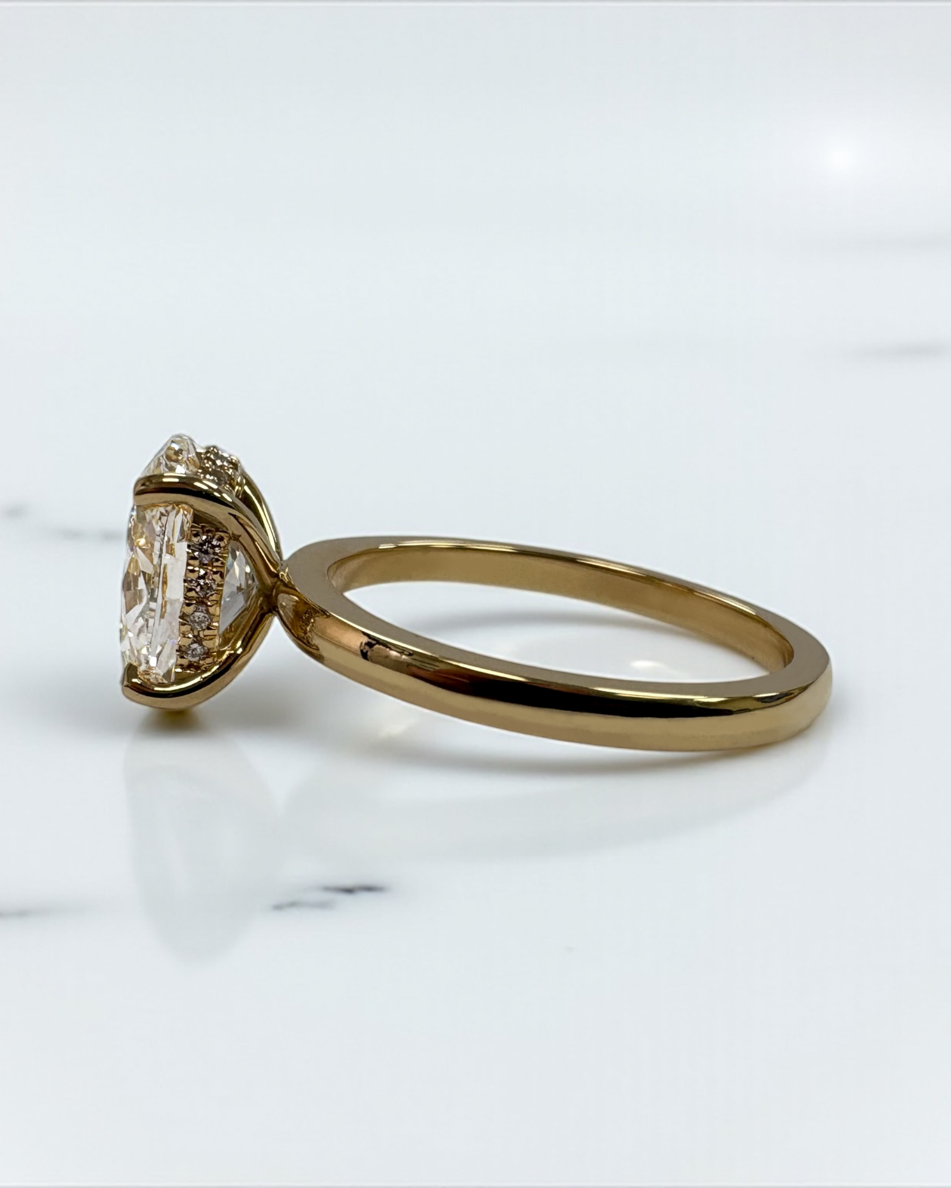 2ct oval cut lab grown diamond floating head engagement ring with hidden halo on a plain soft court band in 18kt yellow gold 