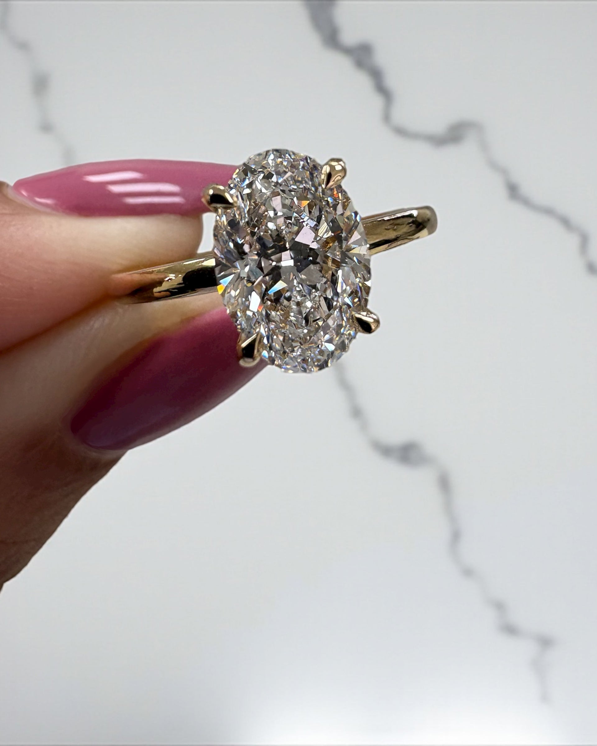2ct oval cut lab grown diamond floating head engagement ring with hidden halo on a plain soft court band in 18kt yellow gold 