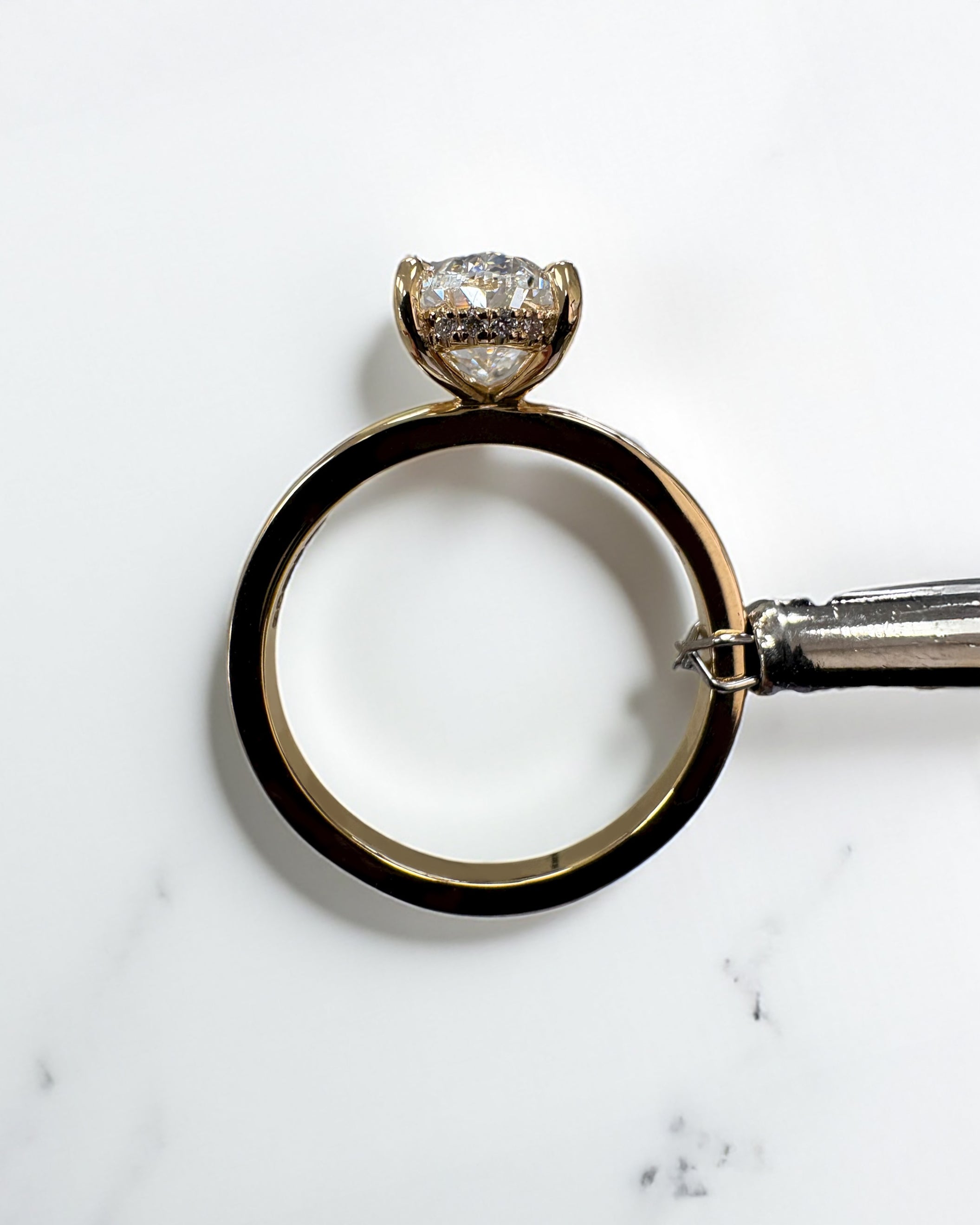 2ct oval cut lab grown diamond floating head engagement ring with hidden halo on a plain soft court band in 18kt yellow gold 