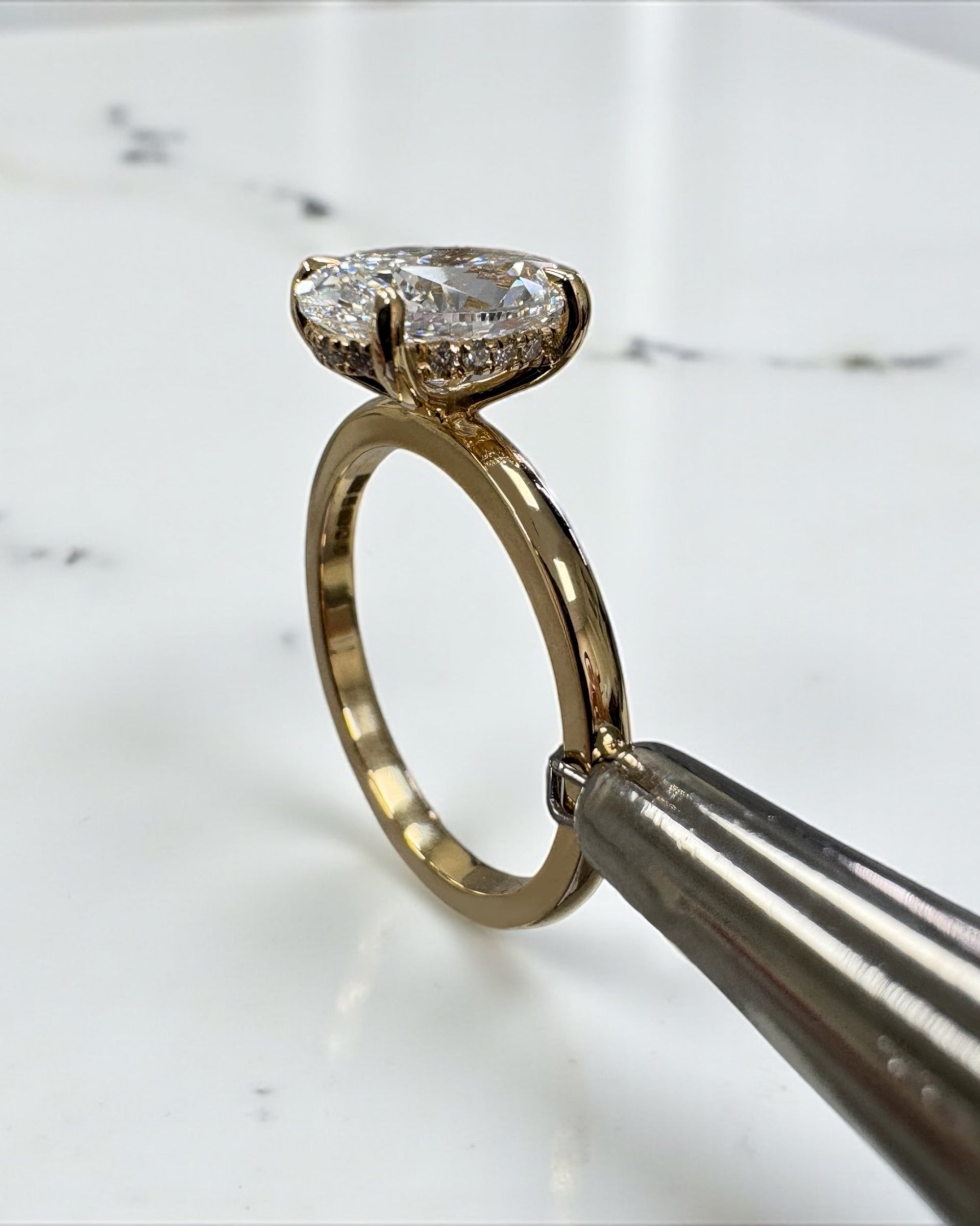2ct oval cut lab grown diamond floating head engagement ring with hidden halo on a plain soft court band in 18kt yellow gold 