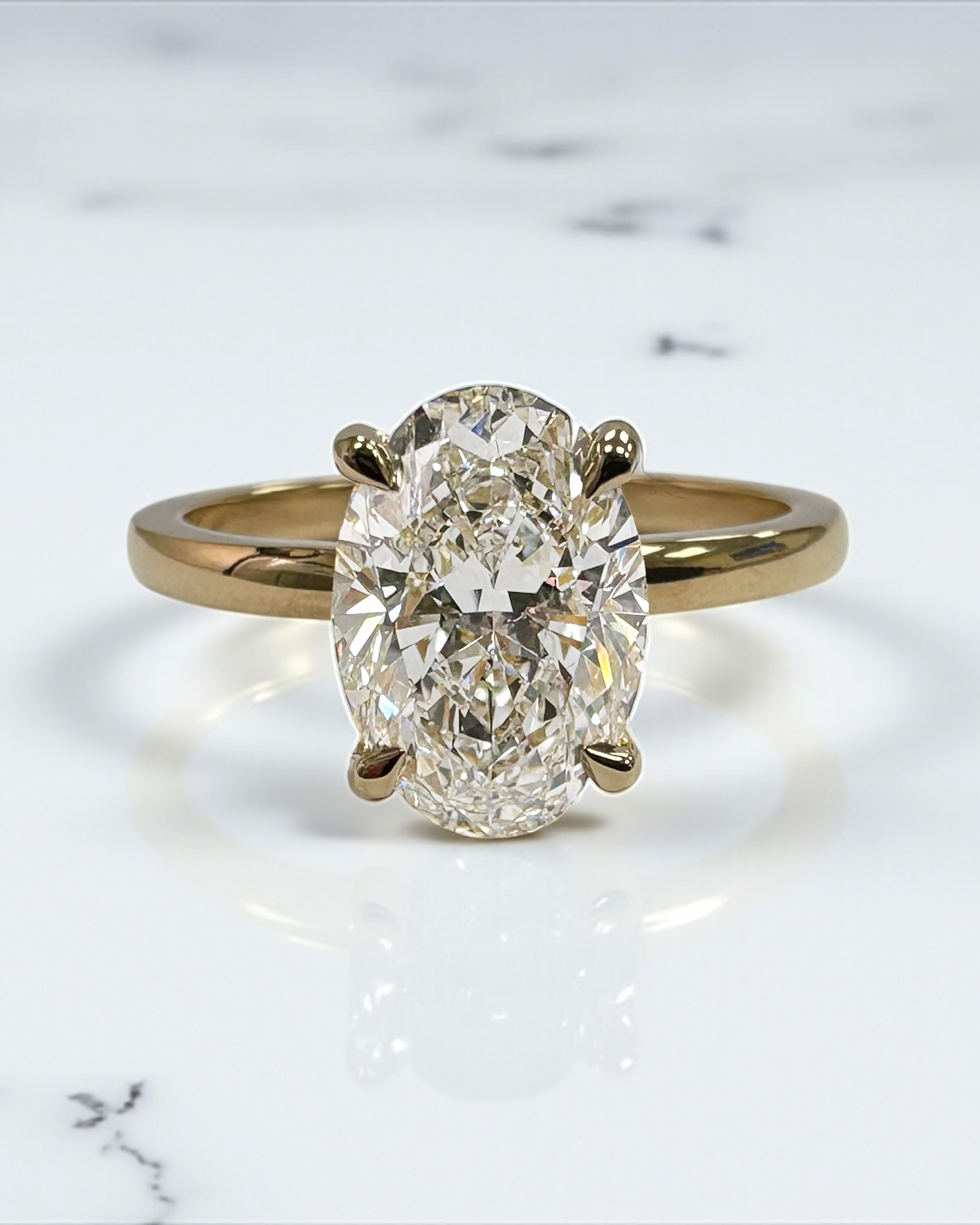 2ct oval cut lab grown diamond floating head engagement ring with hidden halo on a plain soft court band in 18kt yellow gold 