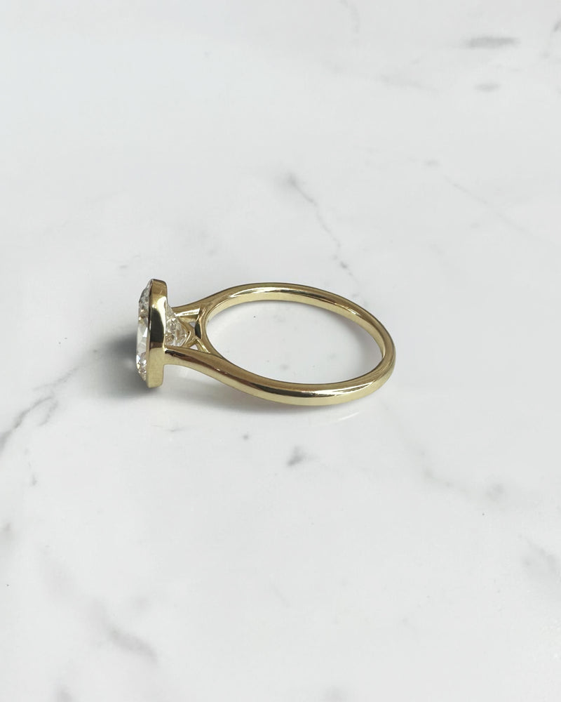 2ct oval cut lab grown diamond bezel set engagement ring in yellow gold with polished solitaire band