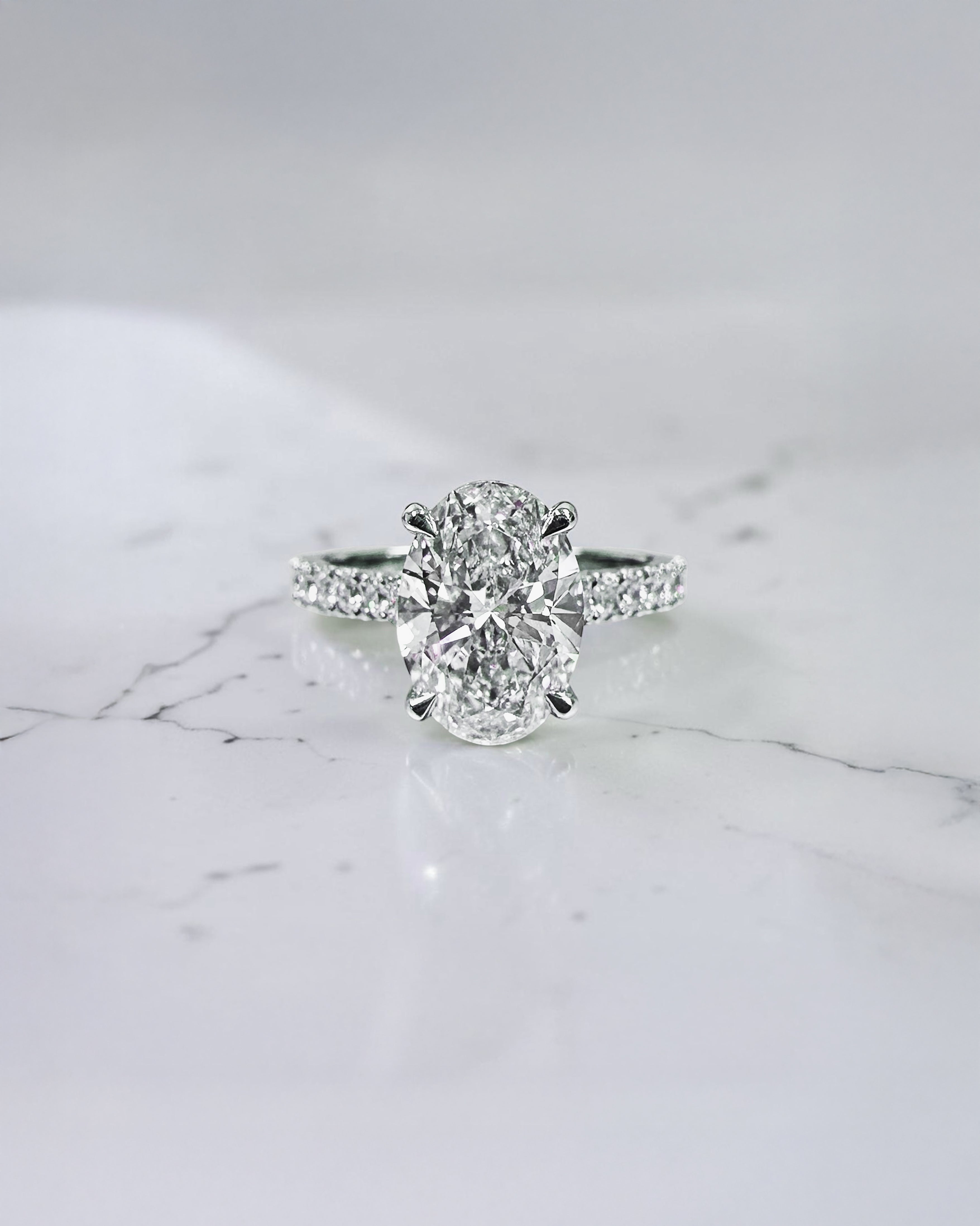 2ct oval cut lab grown diamond cathedral engagement ring with hidden halo, diamond bridge and pavé diamond shoulder band in platinum