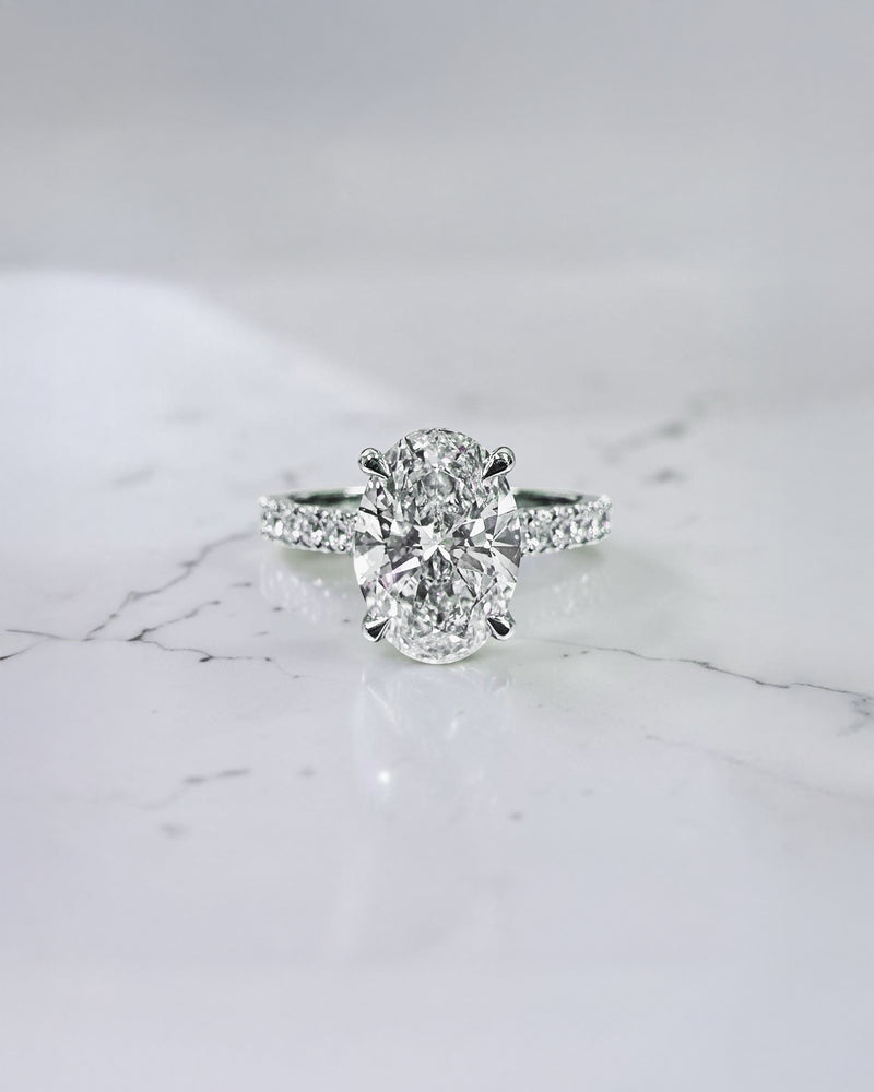 2ct oval cut lab grown diamond cathedral engagement ring with hidden halo, diamond bridge and pavé diamond shoulder band in platinum