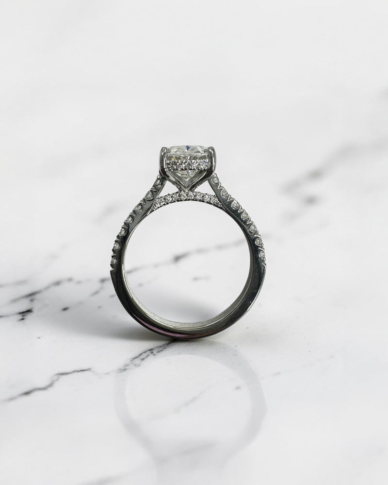 2ct oval cut lab grown diamond cathedral engagement ring with hidden halo, diamond bridge and pavé diamond shoulder band in platinum
