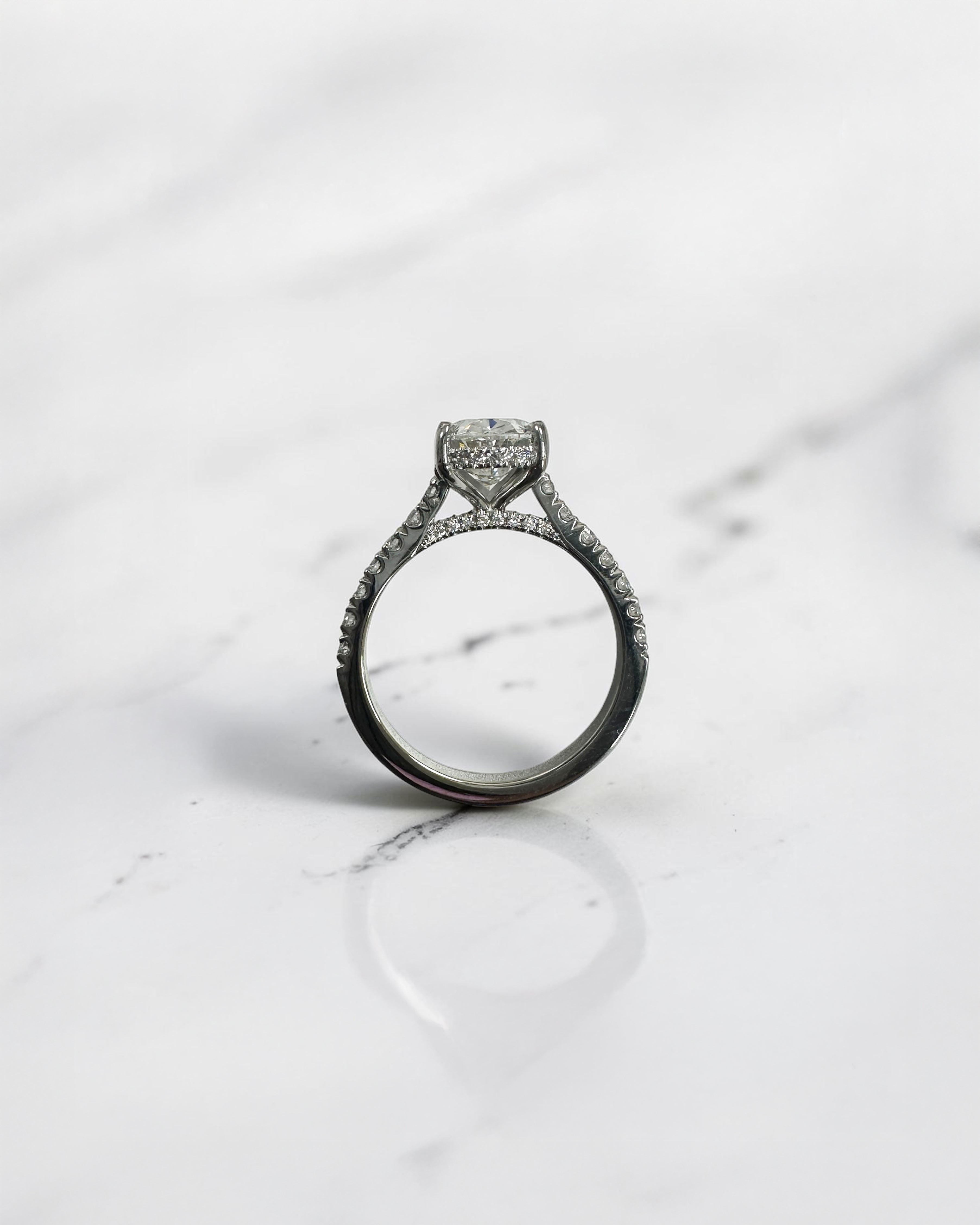 2ct oval cut lab grown diamond cathedral engagement ring with hidden halo, diamond bridge and pavé diamond shoulder band in platinum

