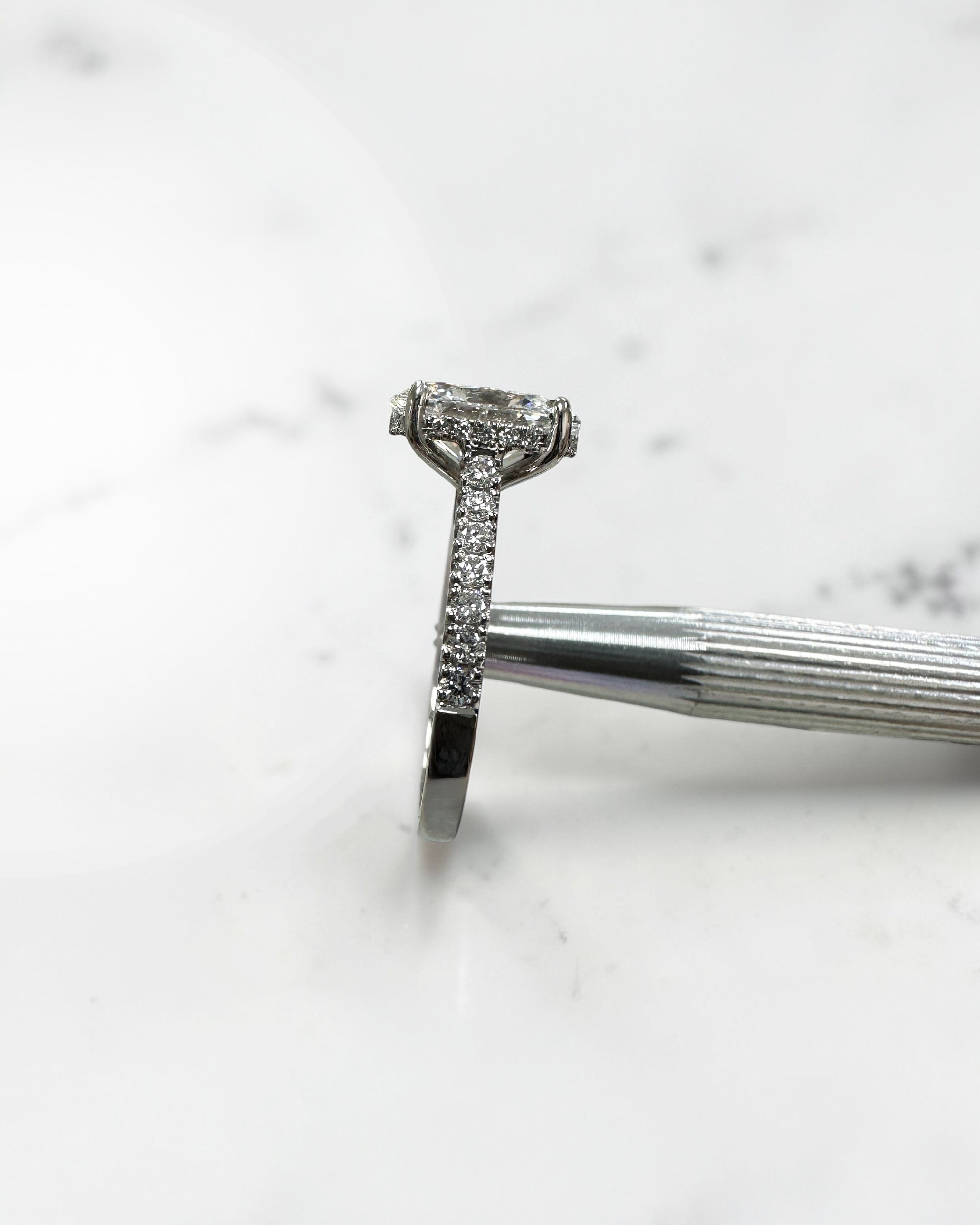 2ct oval cut lab grown diamond cathedral engagement ring with hidden halo, diamond bridge and pavé diamond shoulder band in platinum
