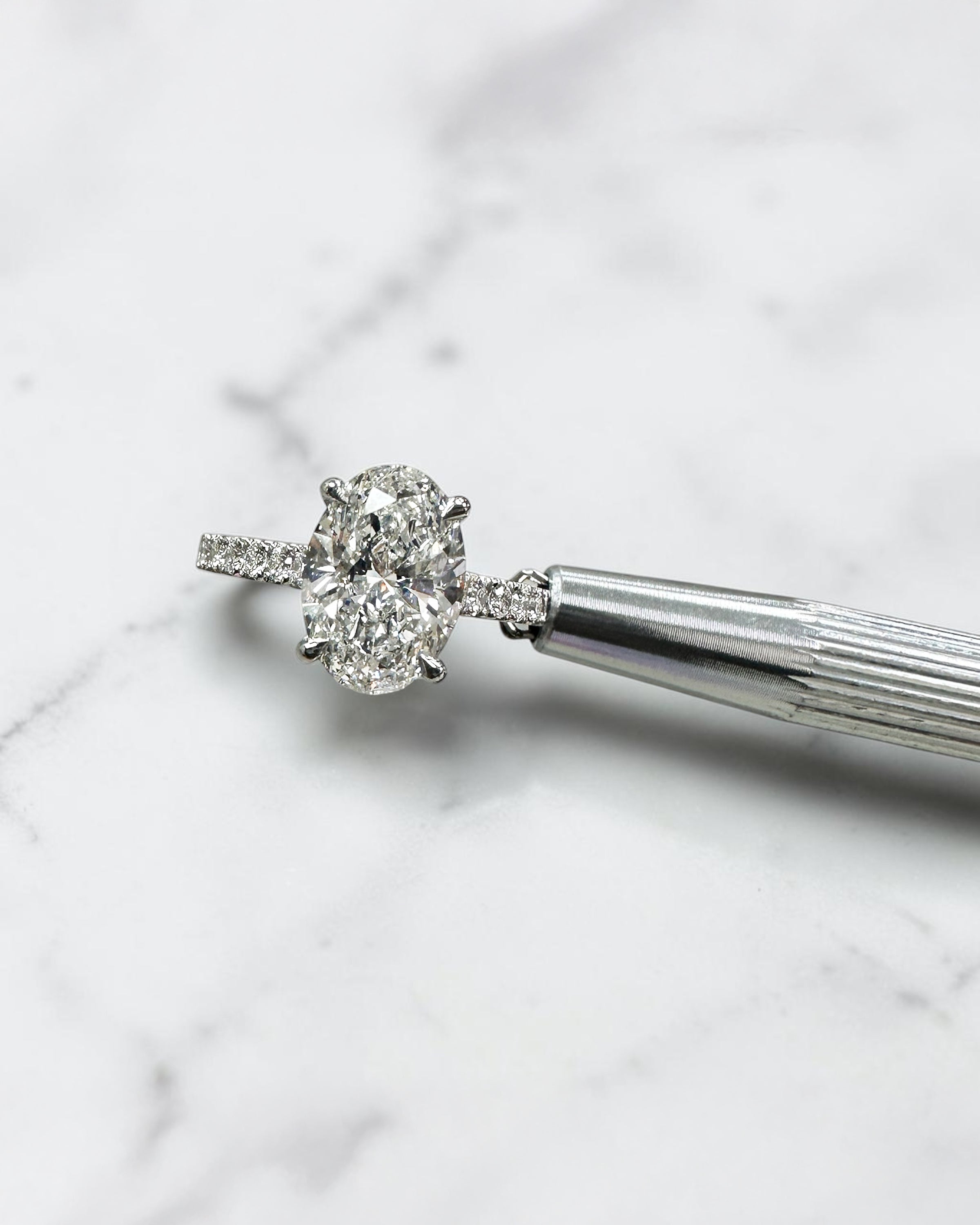 2ct oval cut lab grown diamond cathedral engagement ring with hidden halo, diamond bridge and pavé diamond shoulder band in platinum
