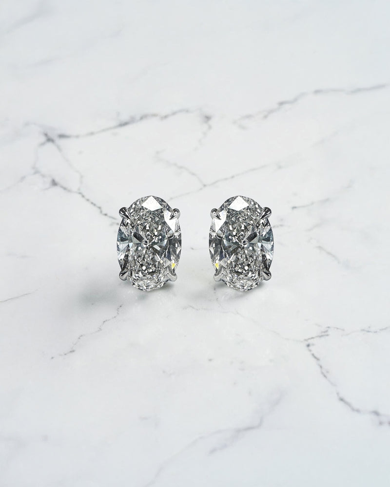 2ct lab grown oval diamond stud earrings featuring two 1ct oval brilliant cut diamonds in a classic four prong setting.