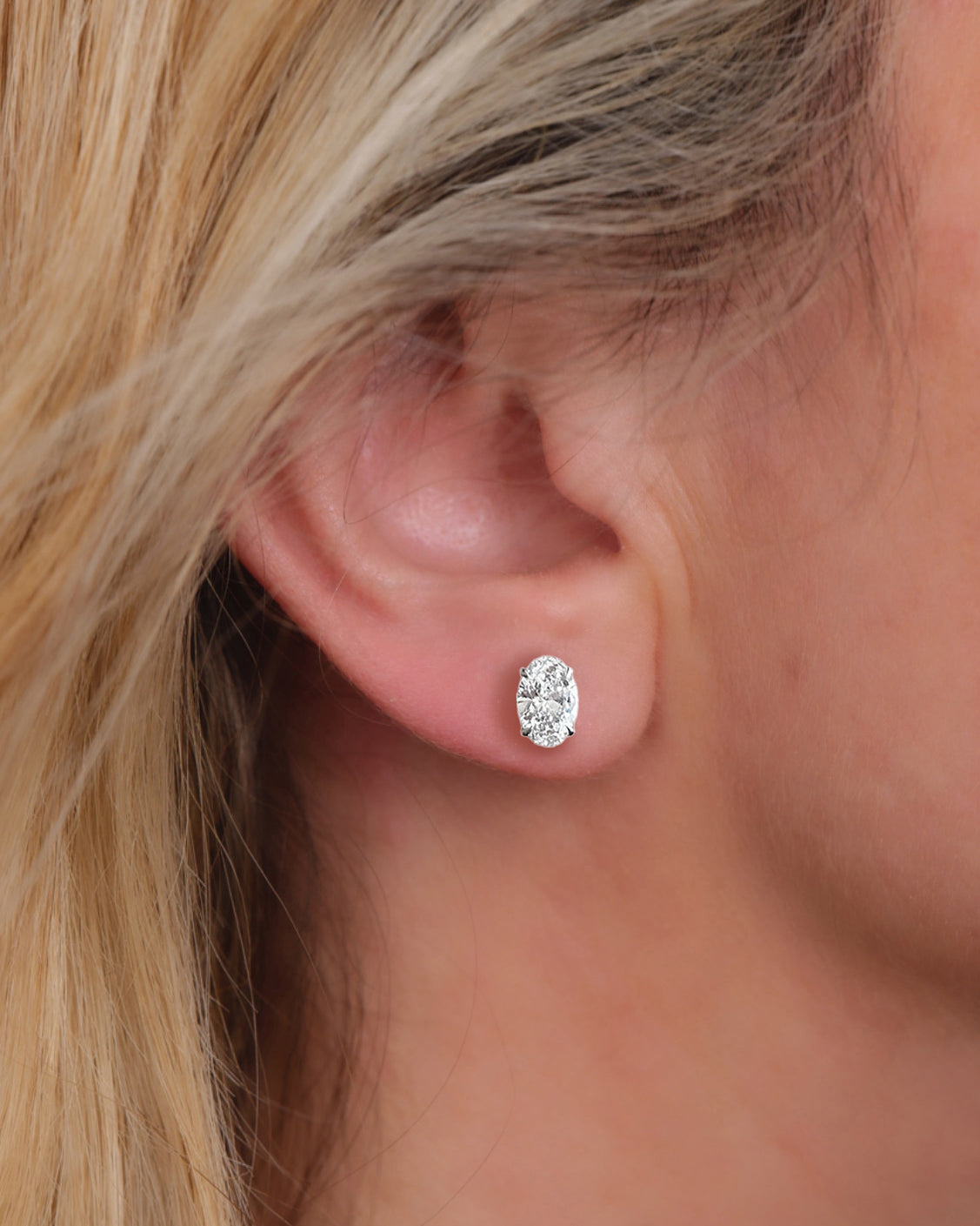 2ct lab grown oval diamond stud earrings featuring two 1ct oval brilliant cut diamonds in a classic four prong setting.