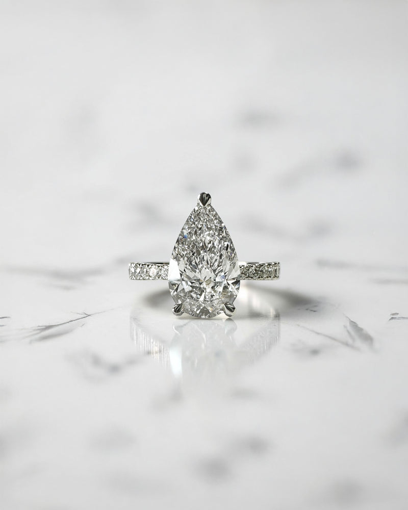 2ct pear cut lab grown diamond engagement ring with tapered diamond shoulder band and lotus three prong setting in platinum, handmade in London.