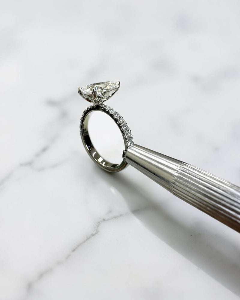 2ct pear cut lab grown diamond engagement ring with tapered diamond shoulder band and lotus three prong setting in platinum, handmade in London.
