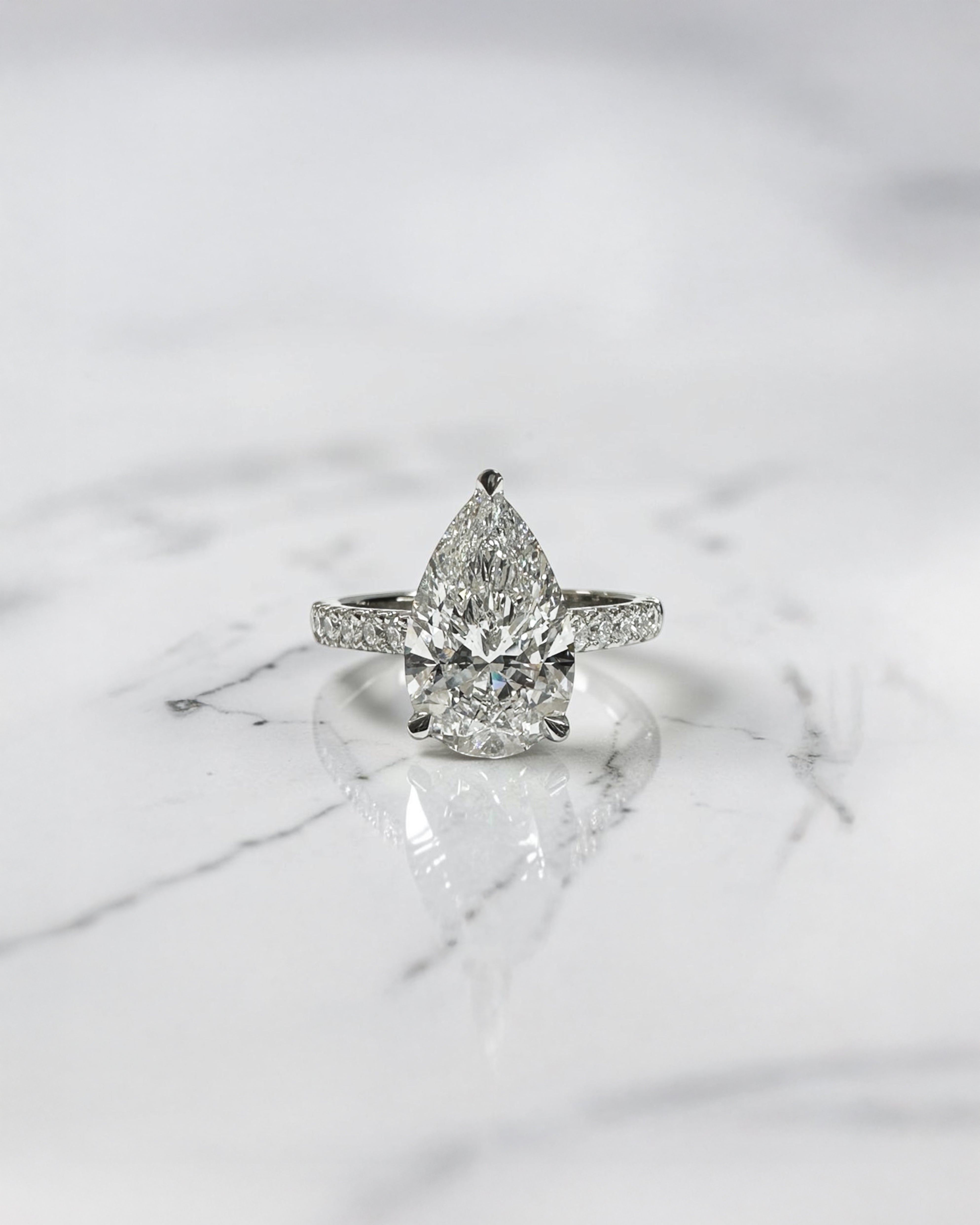 2ct pear cut lab grown diamond engagement ring with cathedral setting, diamond shoulder band, hidden halo and diamond bridge, handcrafted in platinum by Layla Diamonds.
