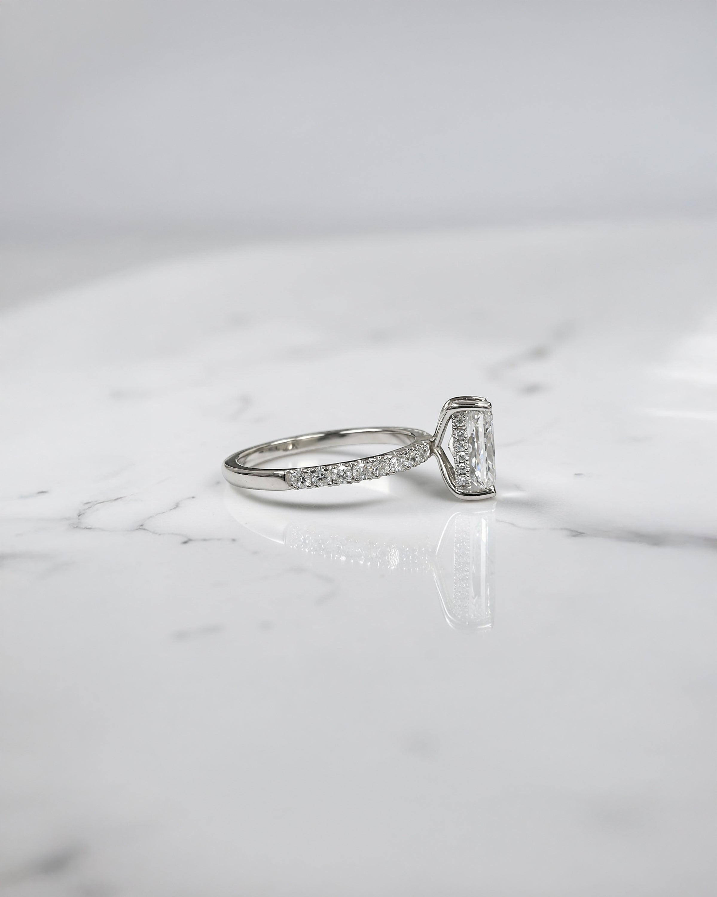 Lab grown 2ct radiant cut diamond engagement ring with hidden halo and pavé diamond shoulders platinum 18kt white gold